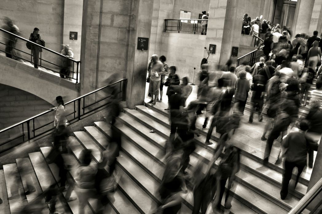 A crowded public space with lots of people walking up and down stairs