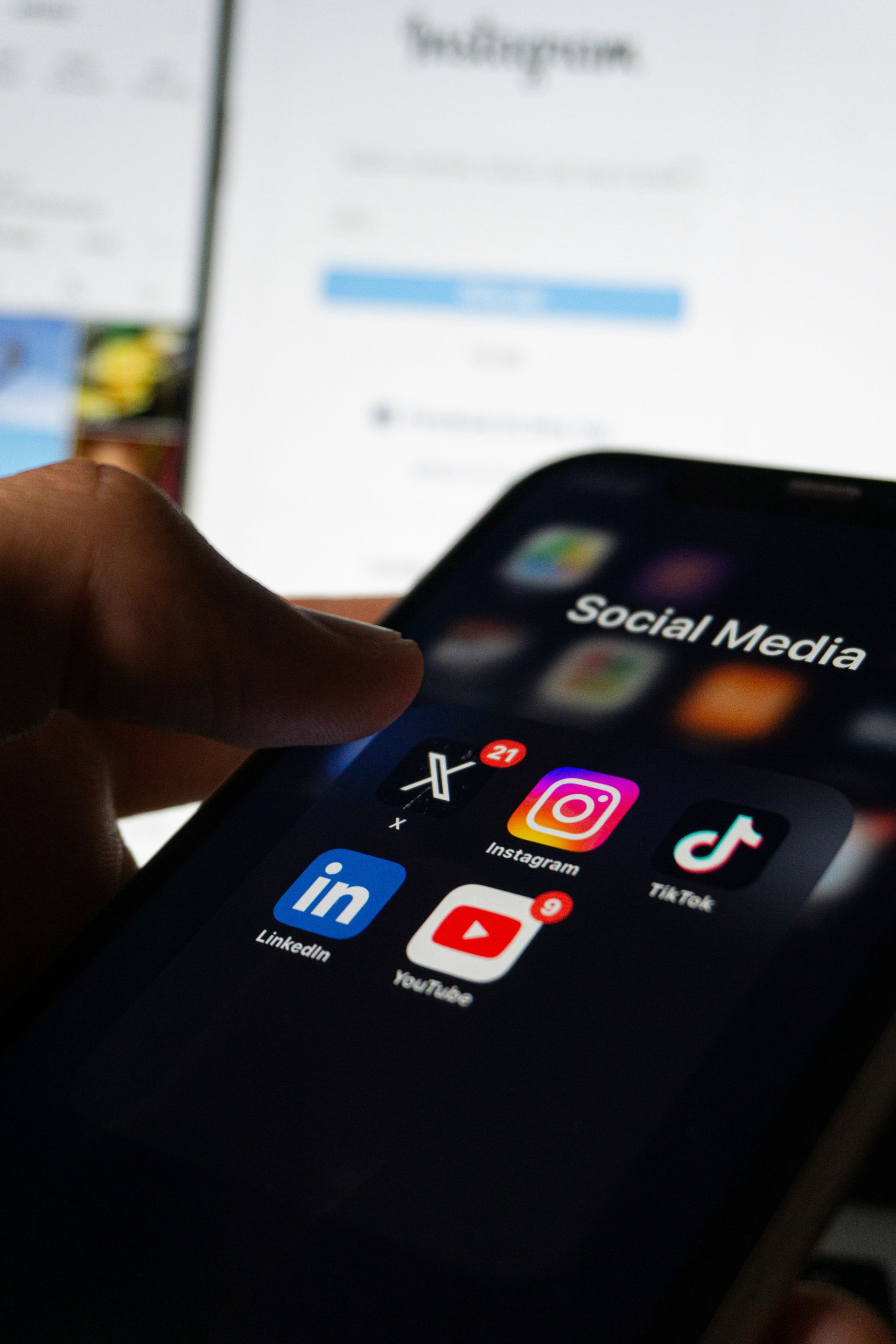 Close up of a person holding a mobile phone showing different social media app icons