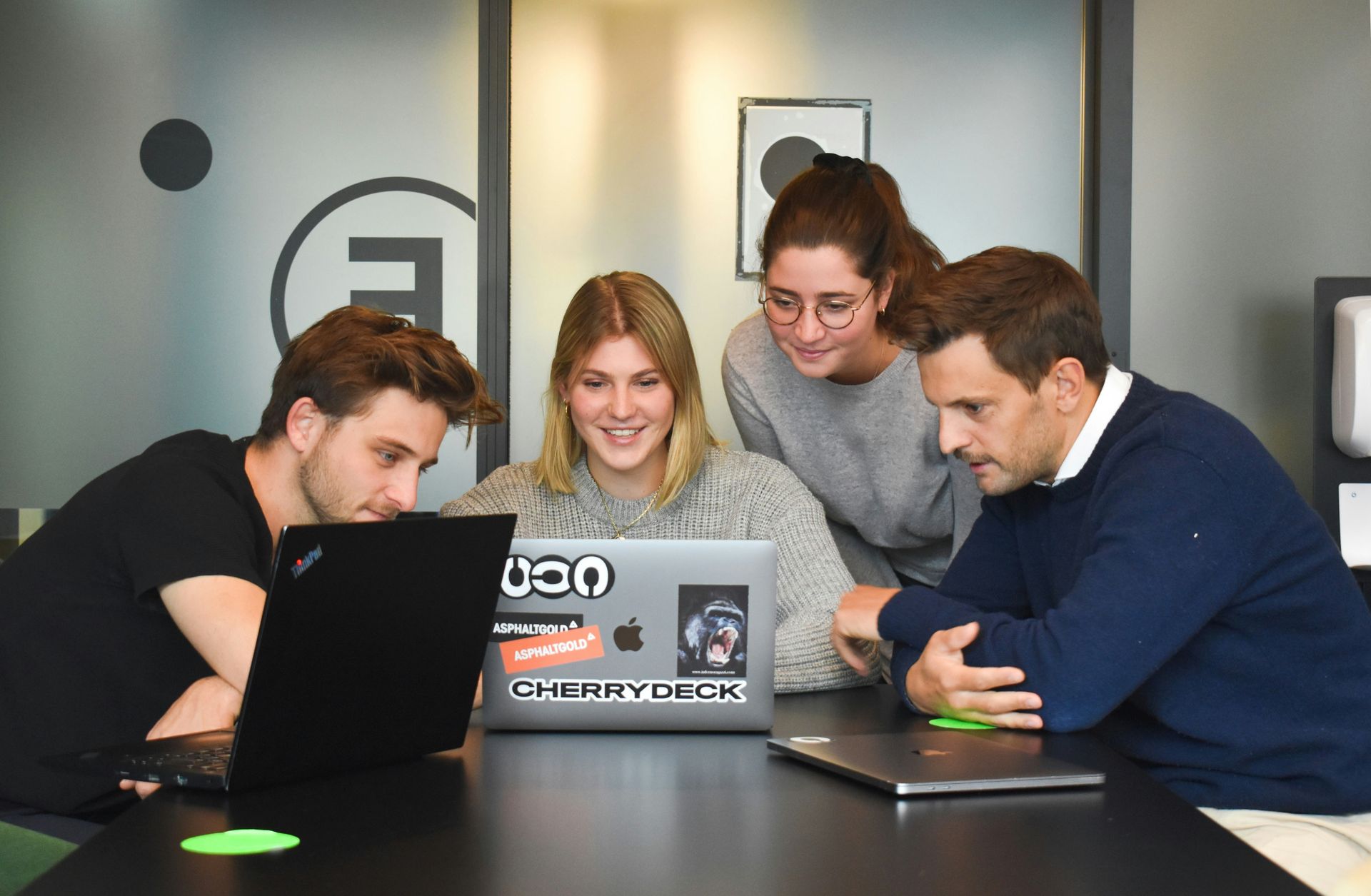 Group of analysts gather around a laptop