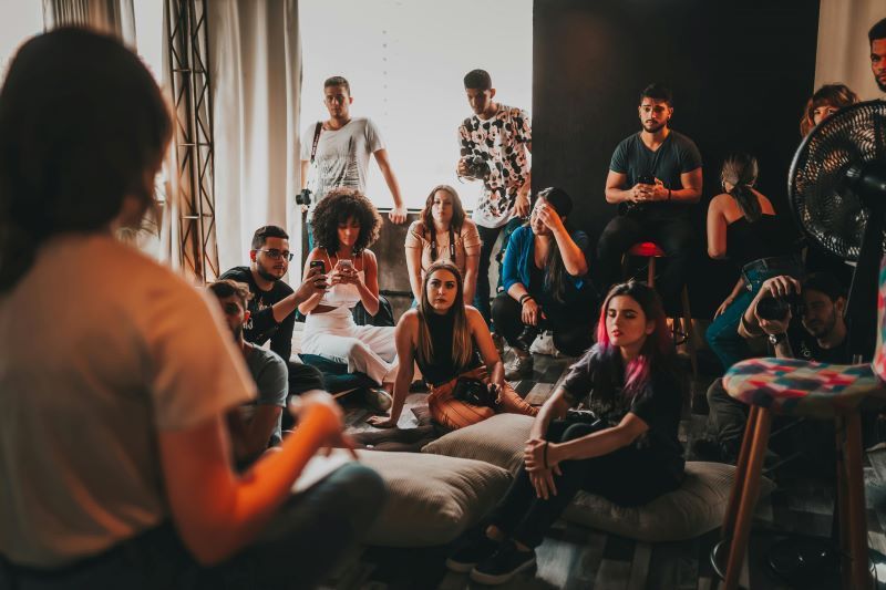 A group of people are gathered around a woman who is telling a story