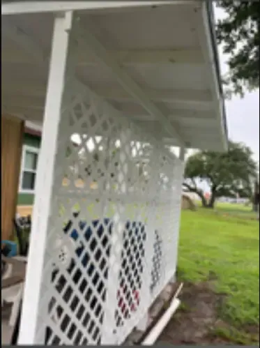White lattice privacy screen on a porch with a green yard in the background.