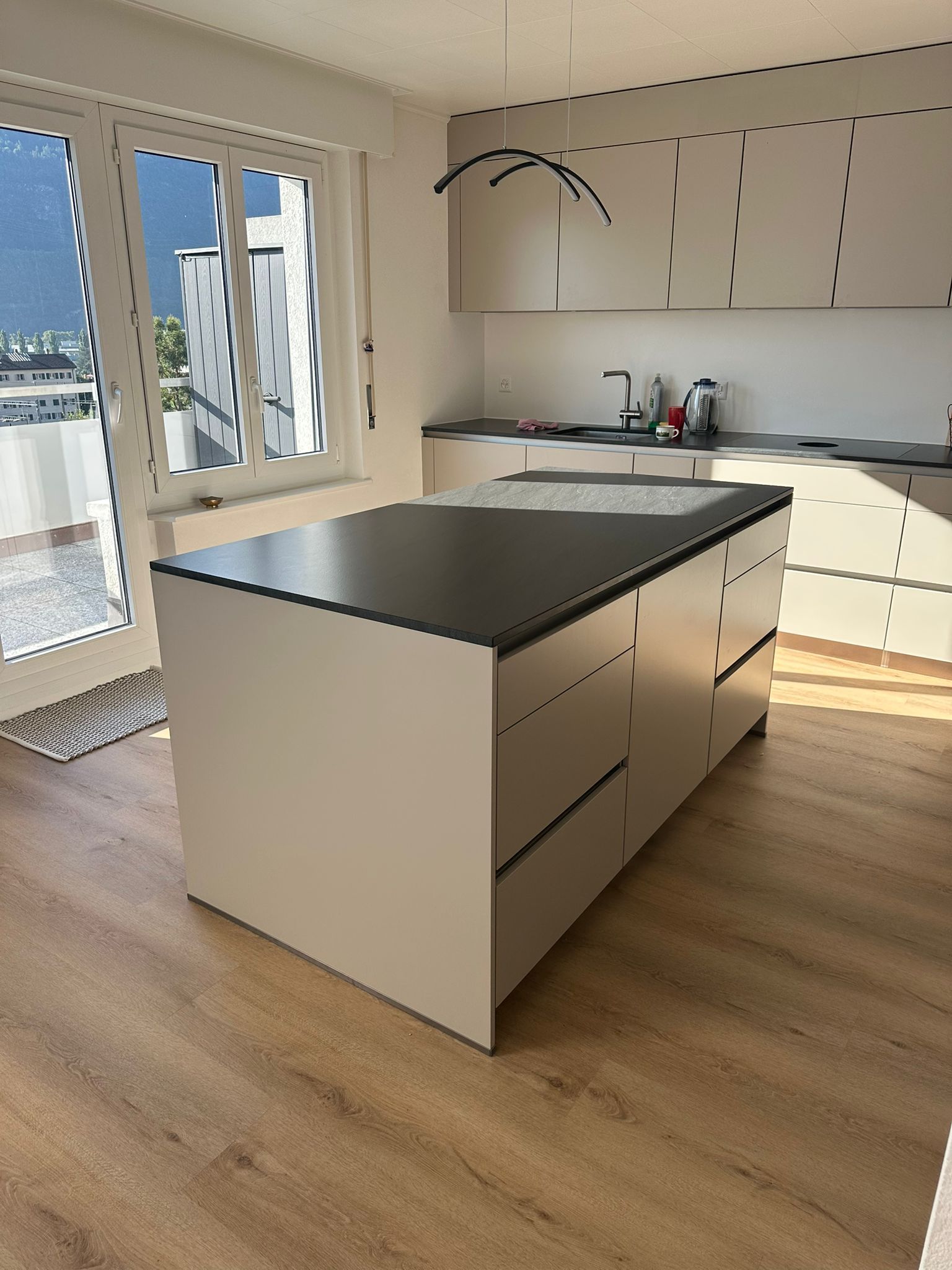 Une cuisine avec des armoires blanches et un grand îlot au milieu