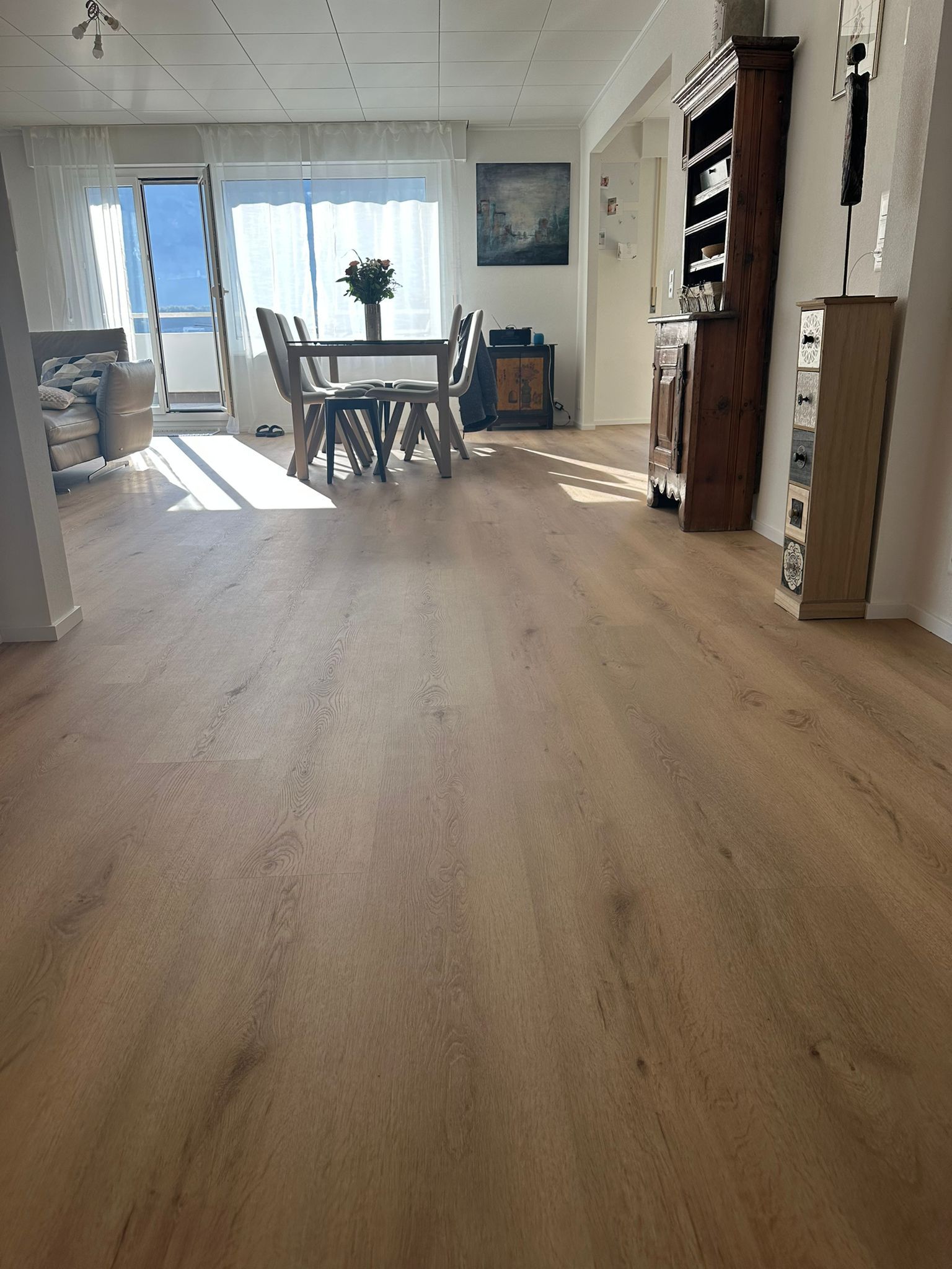 Un salon avec un plancher en bois et une table et des chaises
