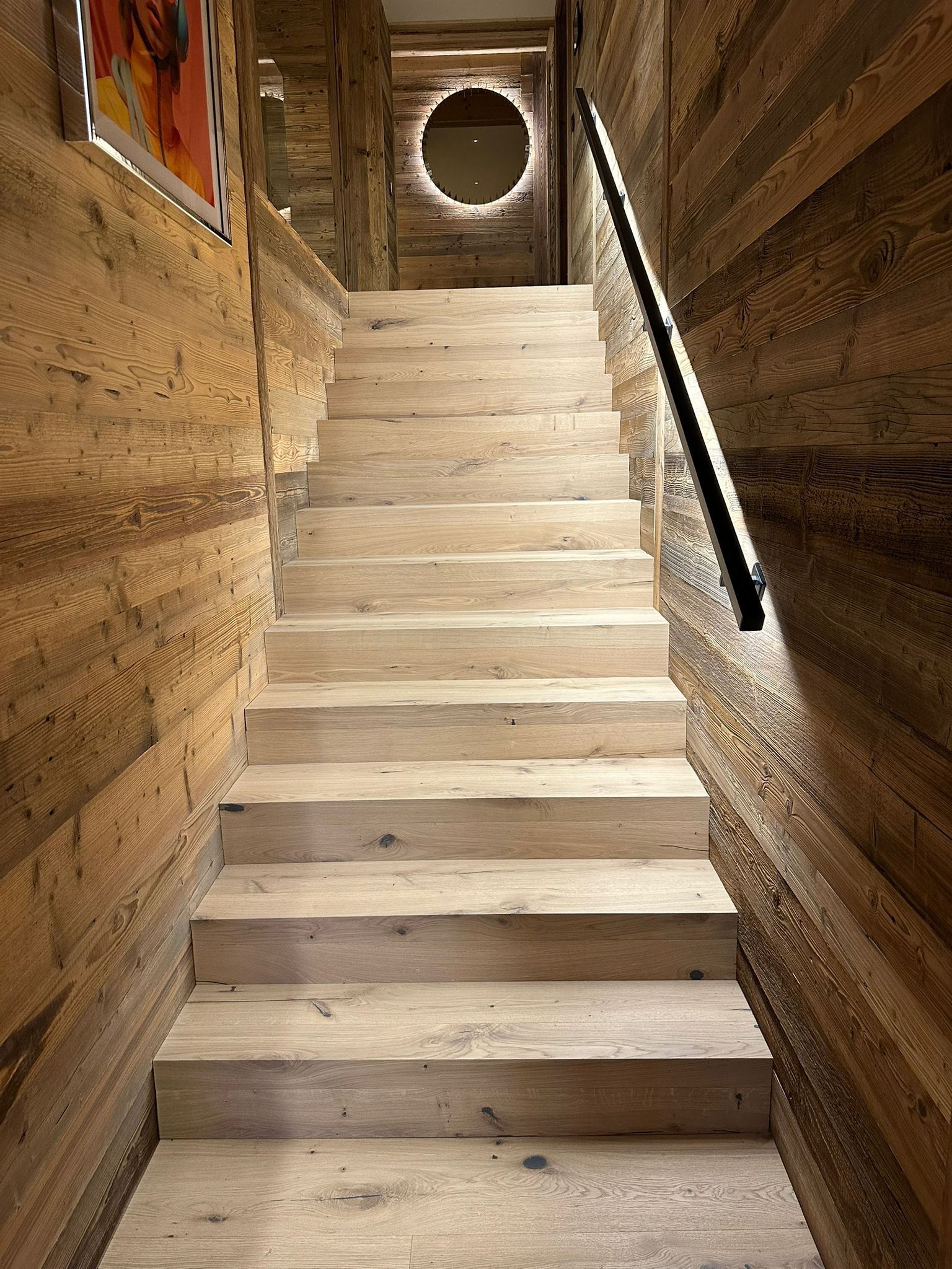 Un ensemble d'escaliers en bois menant à un mur en bois.