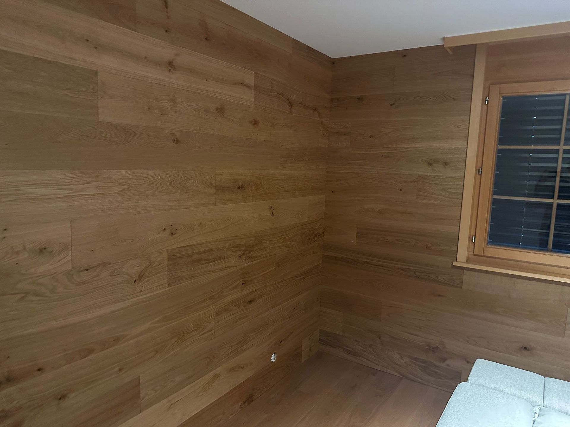 Une pièce avec des murs en bois et une fenêtre.