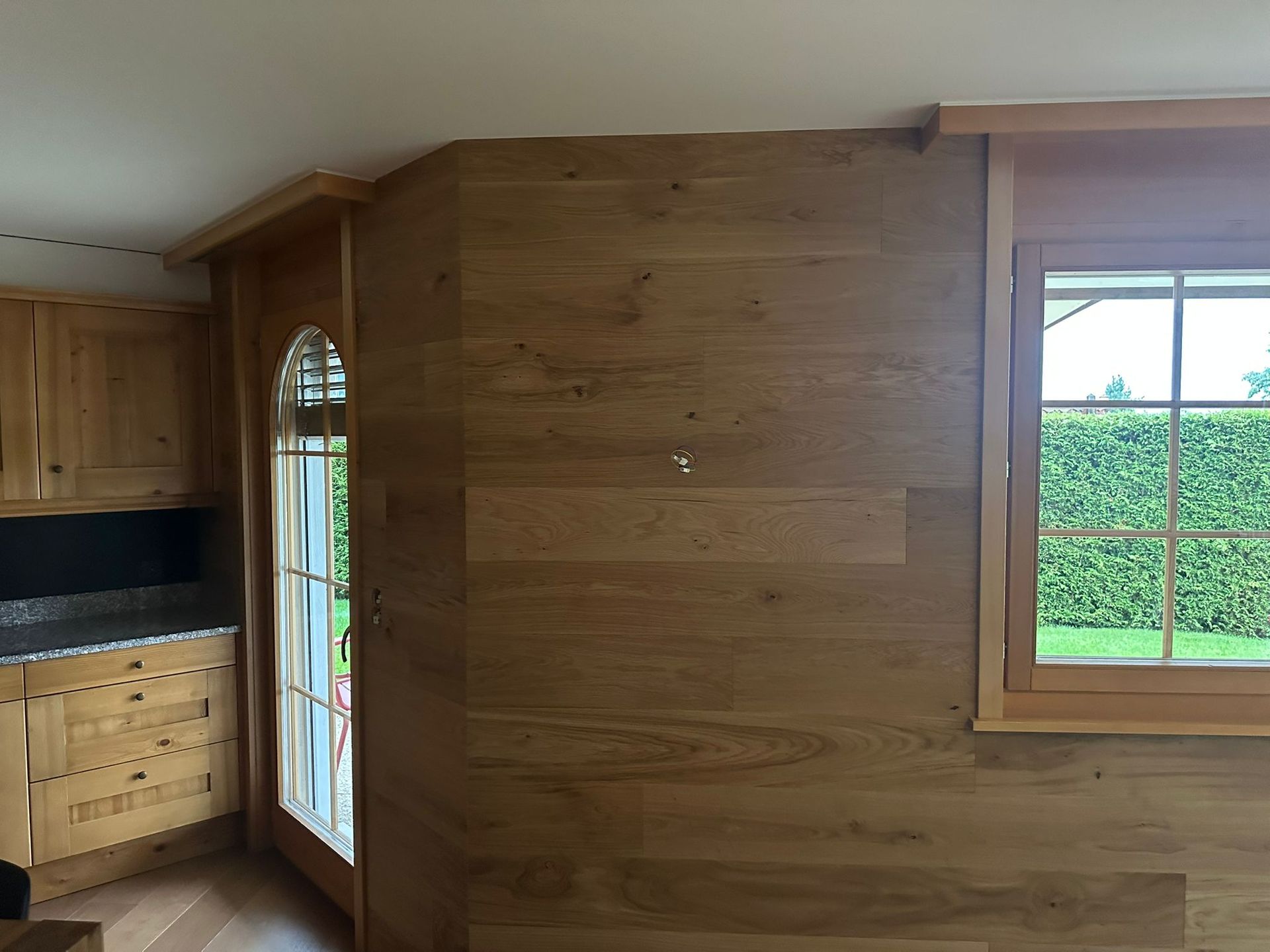 Une cuisine avec un mur en bois et une fenêtre