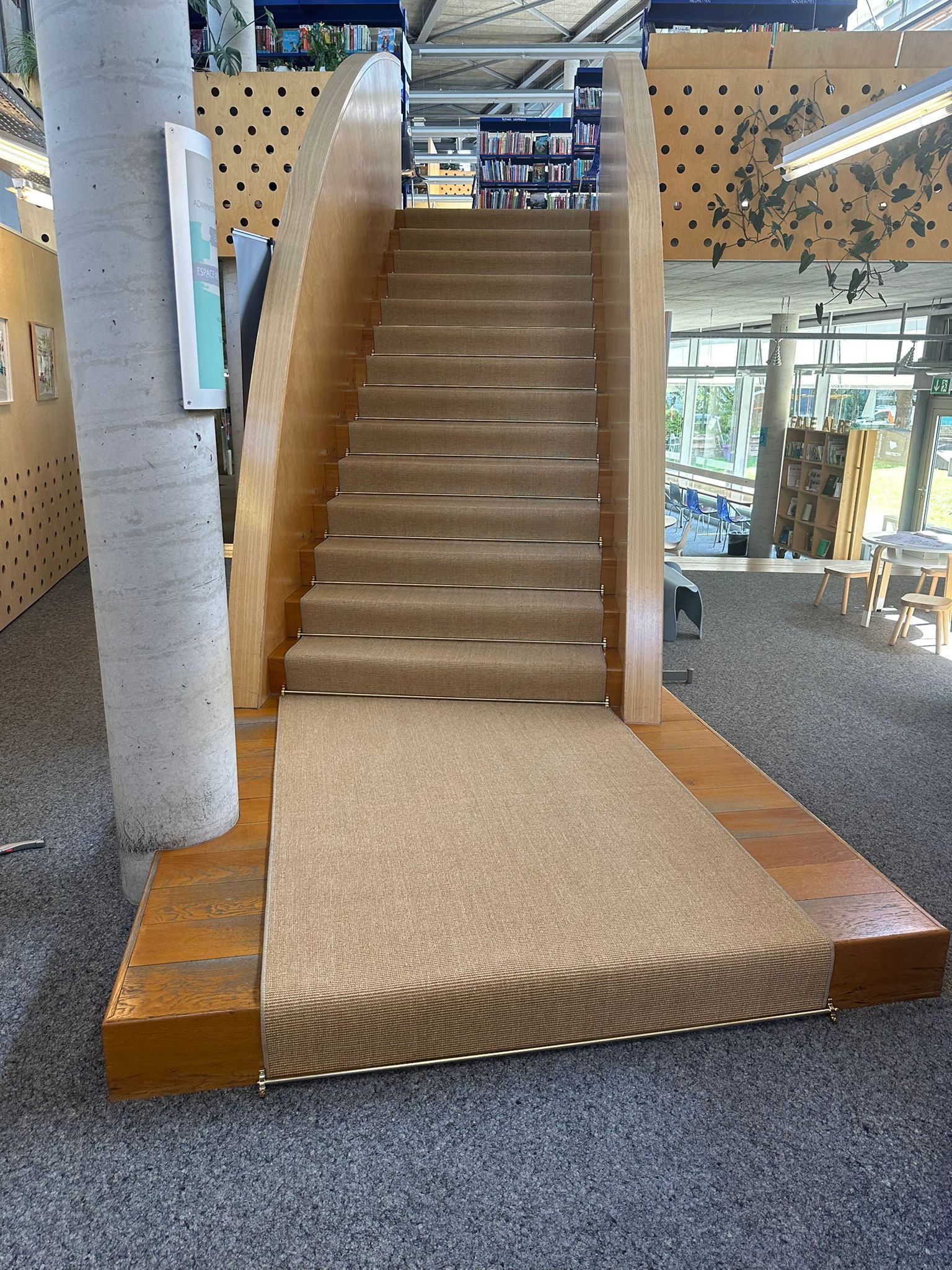 Un ensemble d'escaliers avec une rampe dans une bibliothèque.