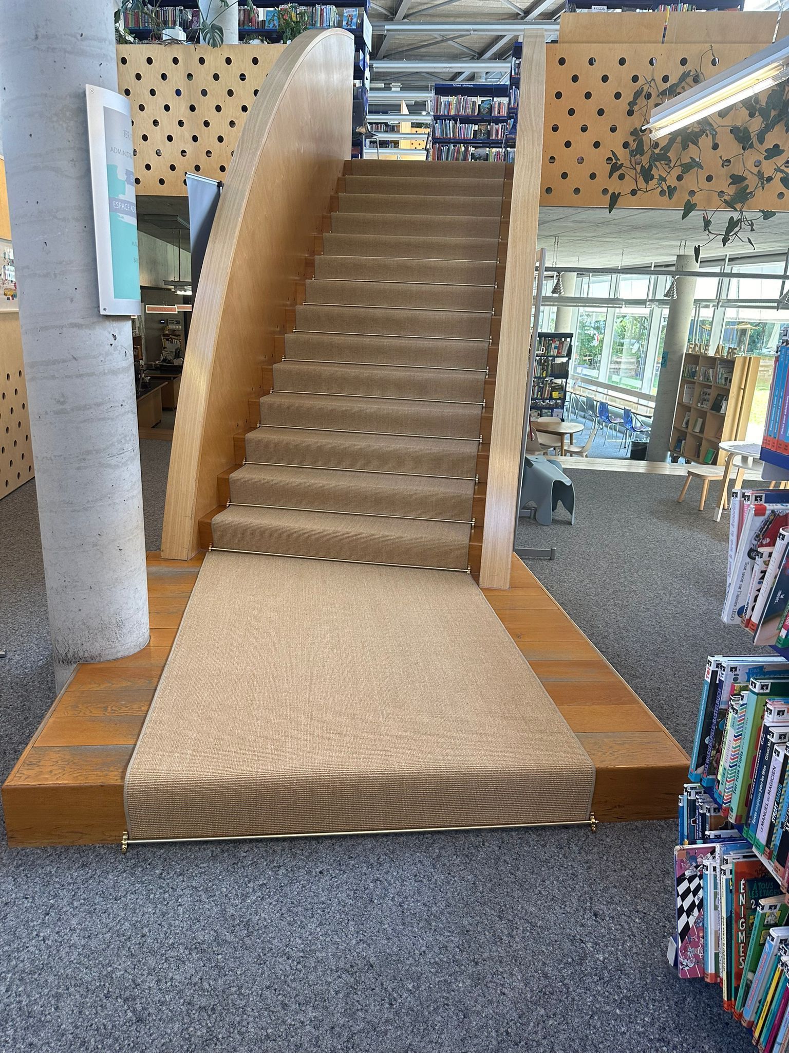 Un ensemble d'escaliers menant à un toboggan dans une bibliothèque.