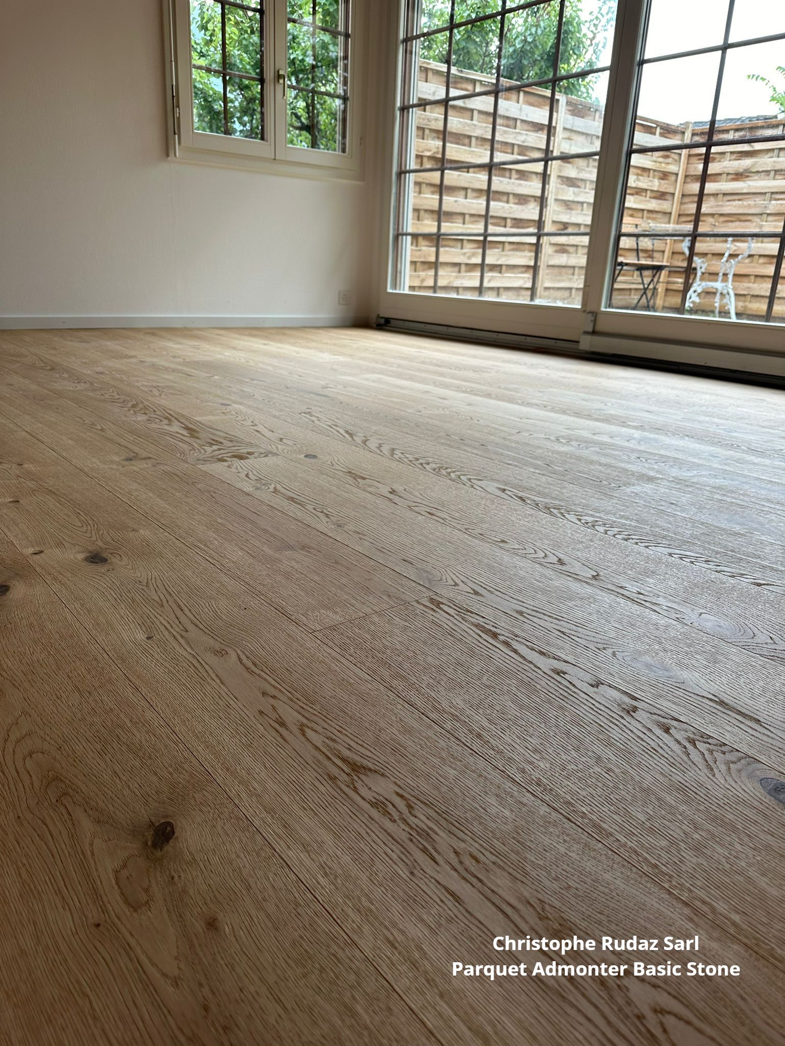 Une pièce vide avec un plancher en bois et une fenêtre.
