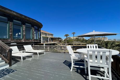 There is a large deck with a table and chairs on it.