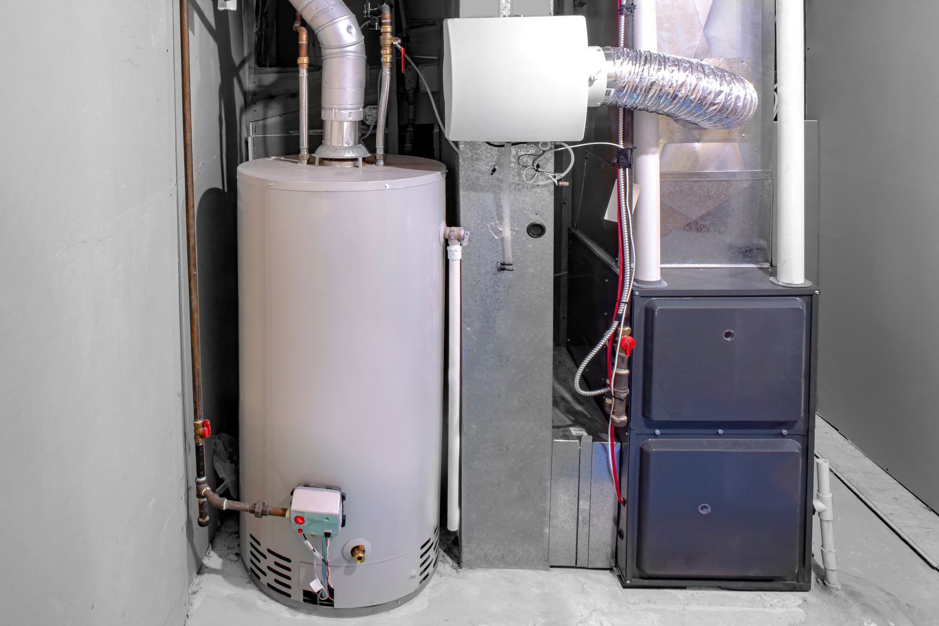 Image of a high-efficiency furnace being installed in a residential home, accompanied by a gas water heater and a humidifier.