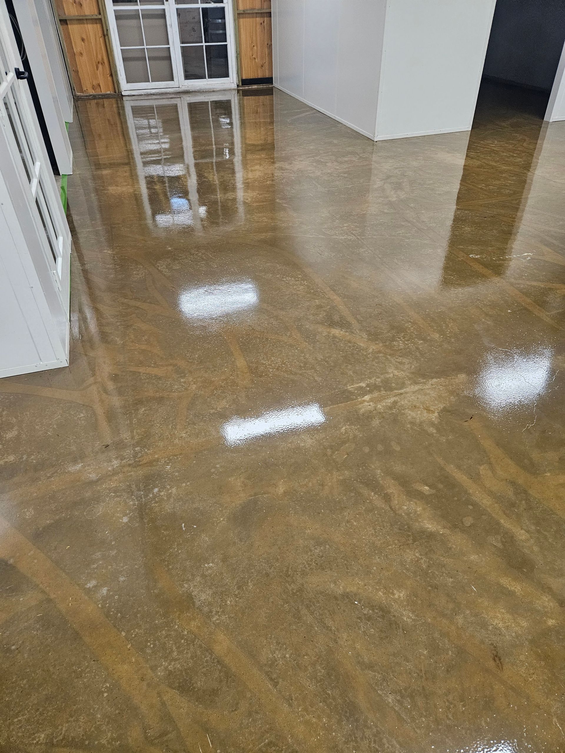 Polished concrete floor reflecting a window, wood shutters, and white walls — Riverina Epoxy Flooring In Glenfield Park, NSW
