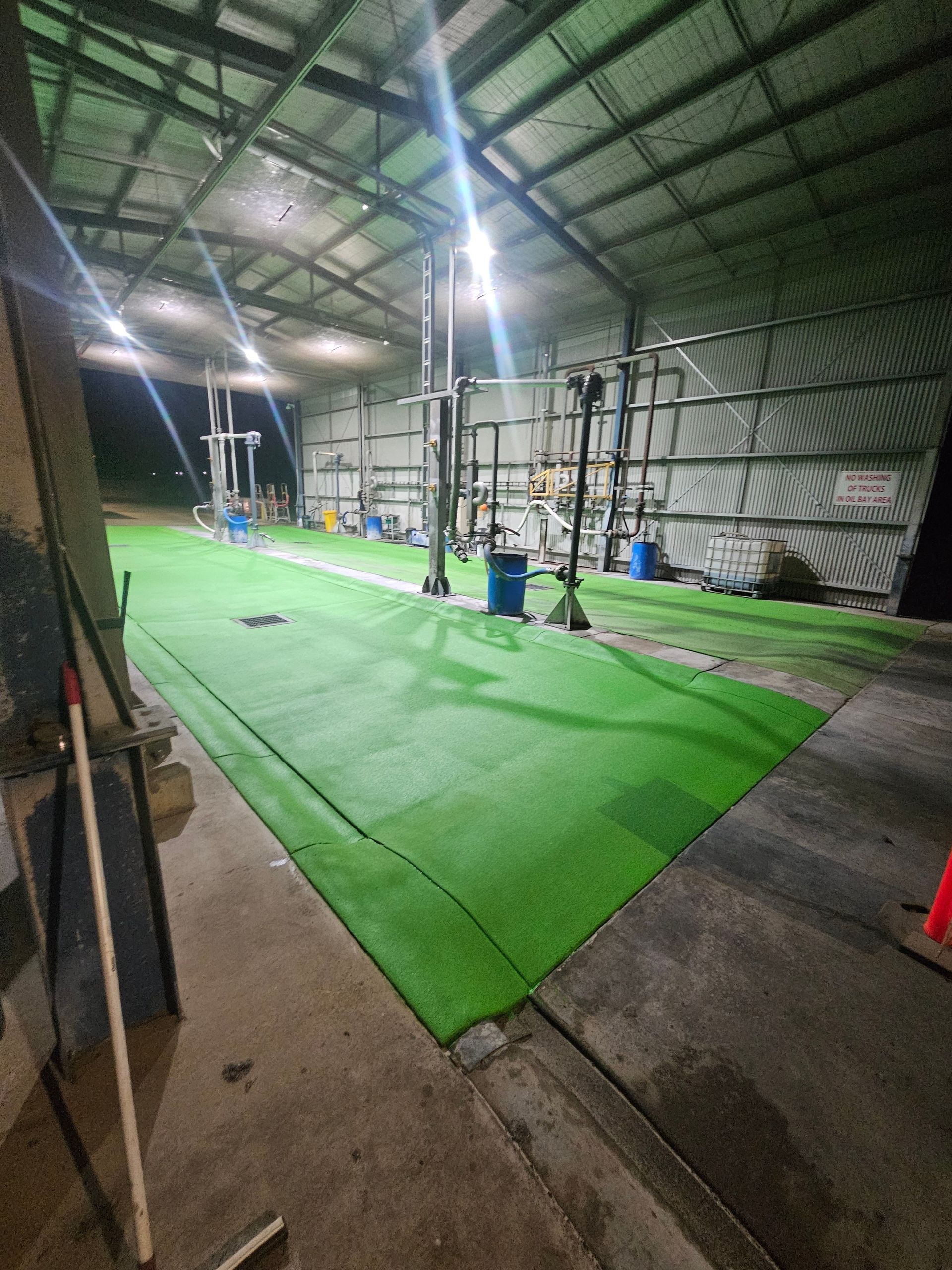 Indoor space with green turf and equipment, under bright lights — Riverina Epoxy Flooring In Glenfield Park, NSW