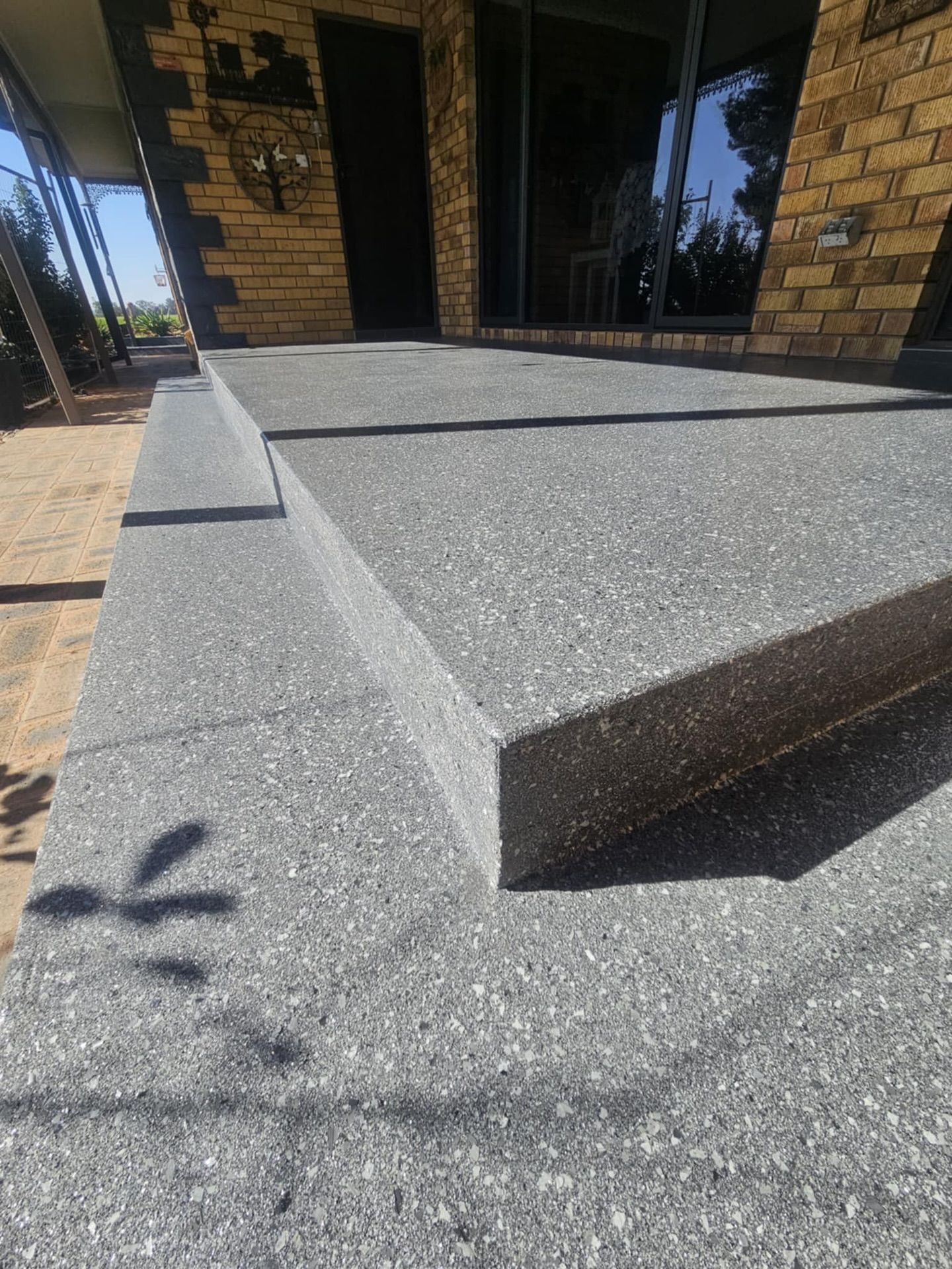 Concrete Steps Leading Up to a House With Brick and Glass Elements — Riverina Epoxy Flooring In Glenfield Park, NSW
