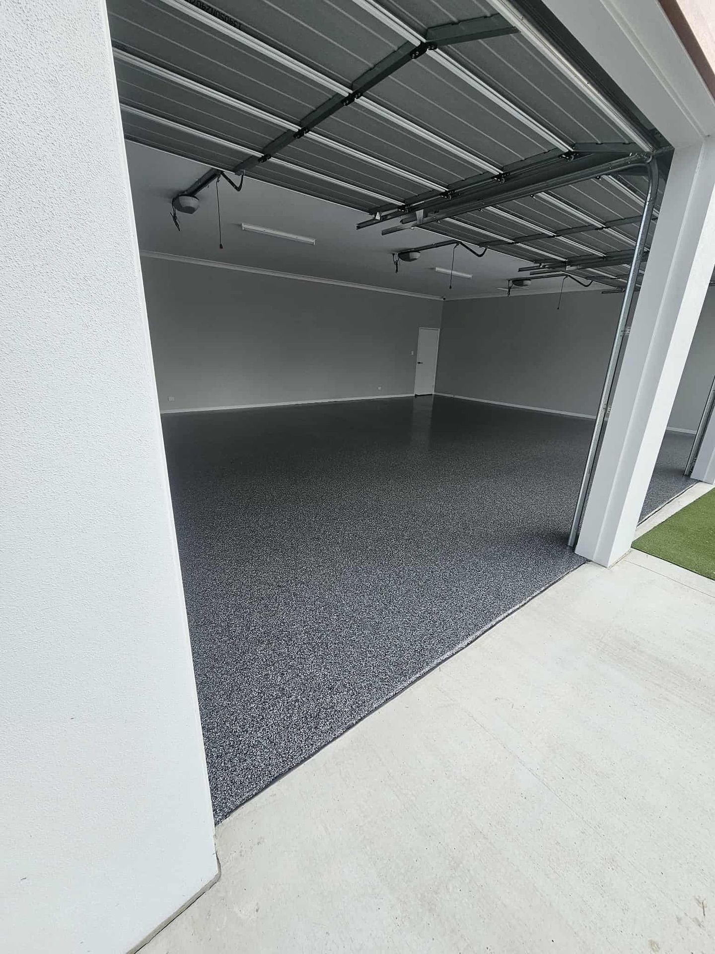 Open garage with gray speckled floor and white walls — Riverina Epoxy Flooring In Glenfield Park, NSW