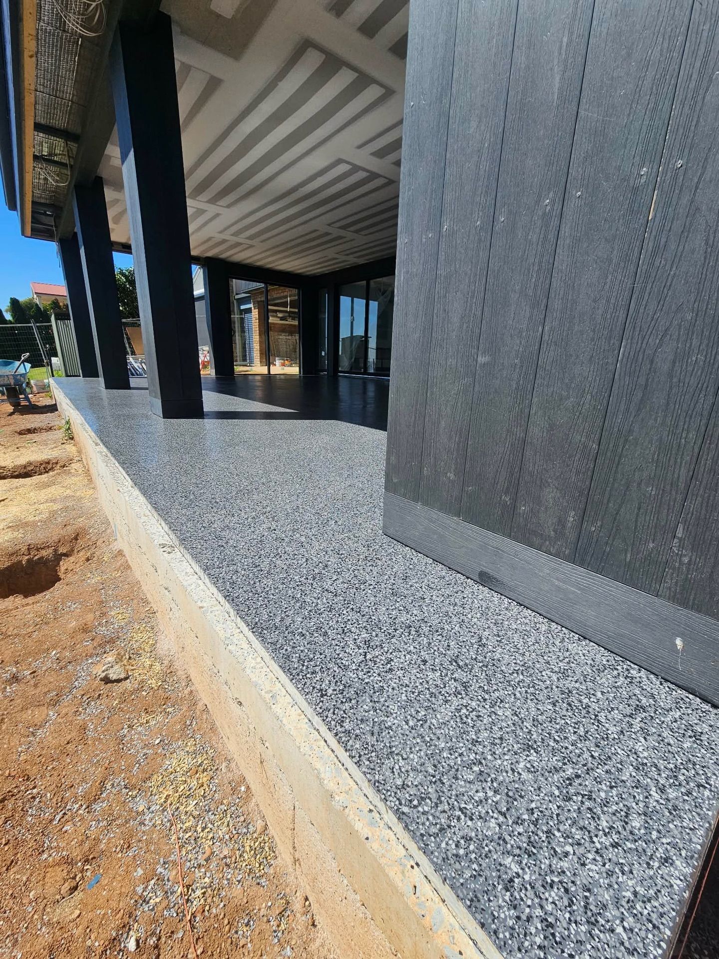 A low-angle view of a new patio with grey stone surface — Riverina Epoxy Flooring In Glenfield Park, NSW