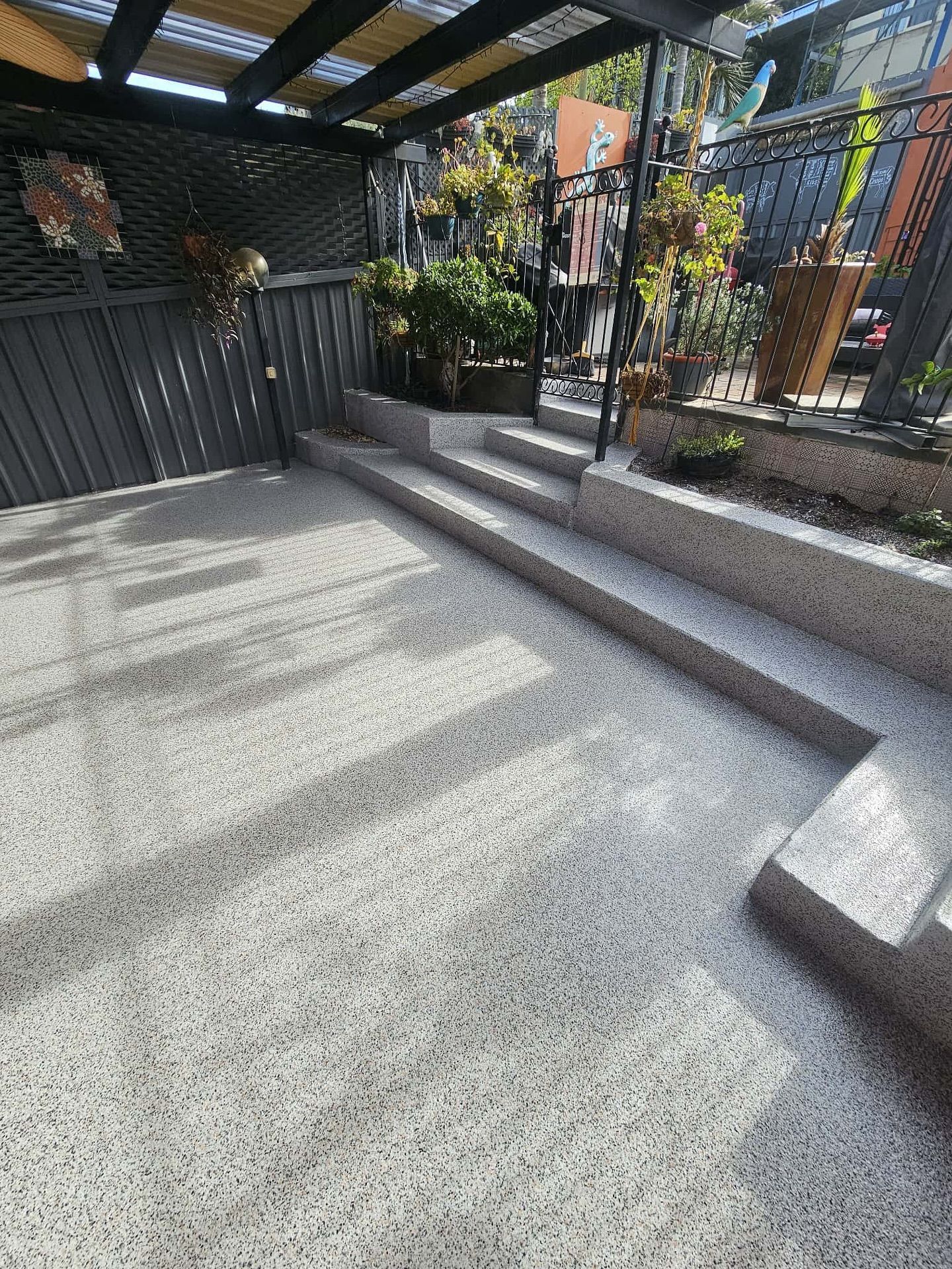 Concrete patio with steps, raised planter bed, and a partially covered area — Riverina Epoxy Flooring In Glenfield Park, NSW