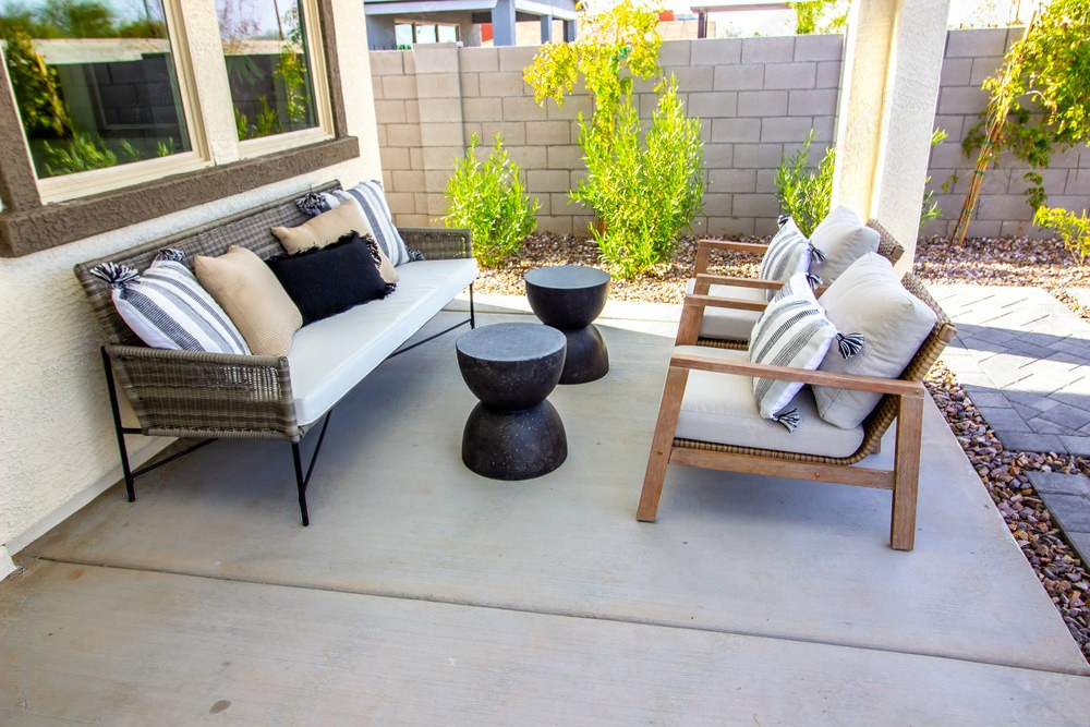 A patio with a couch and chairs on it .