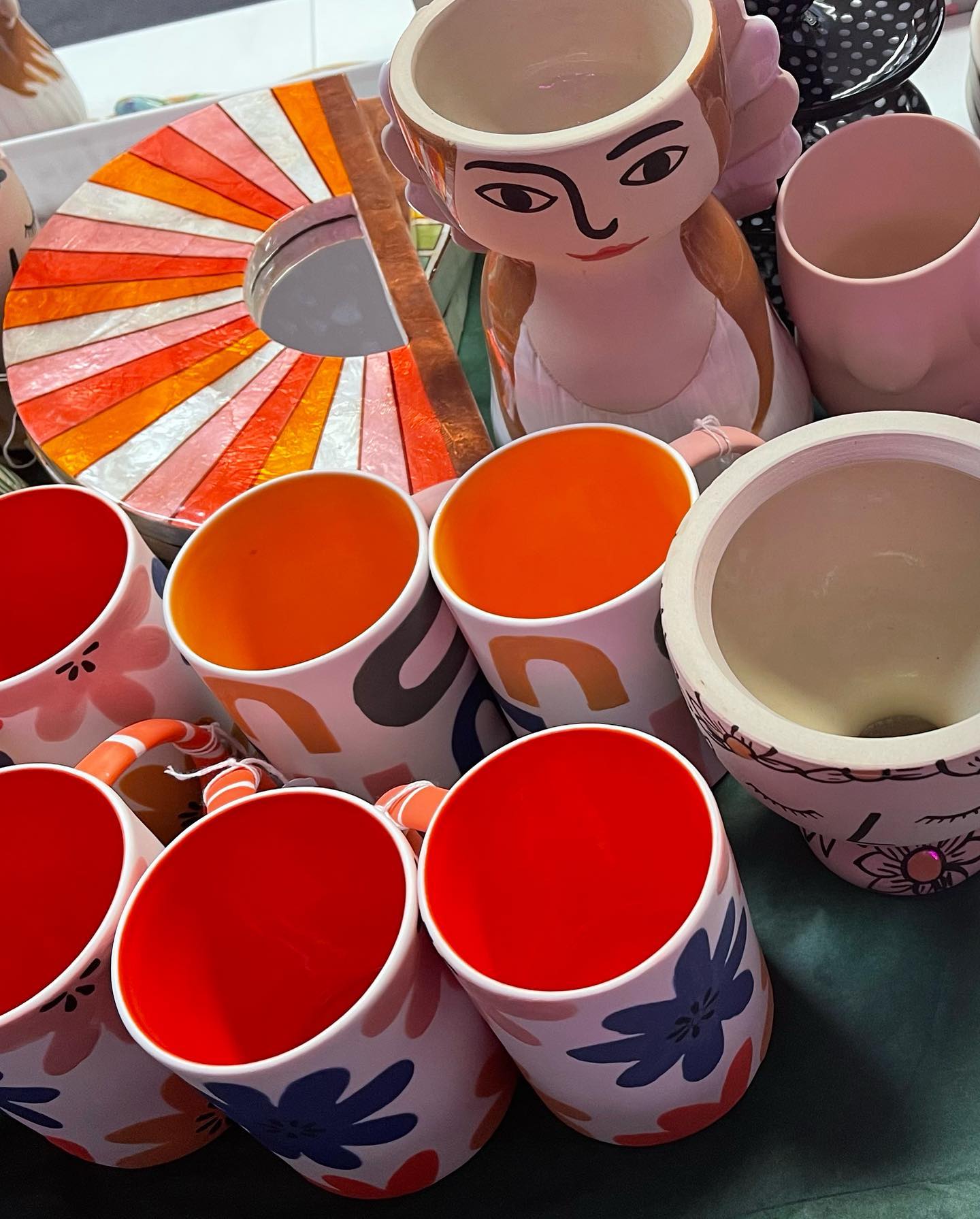 A bunch of different colored cups and bowls on a table