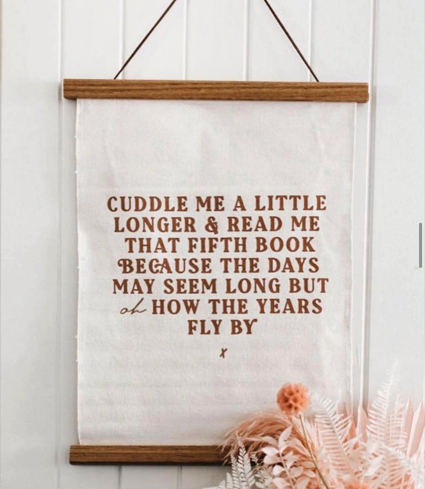 A sign that says cuddle me a little longer and read me that fifth book because the days may seem long but how the years fly by