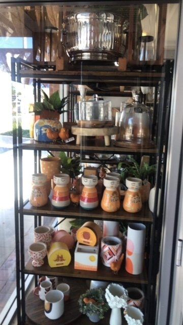 A shelf filled with lots of pots and vases