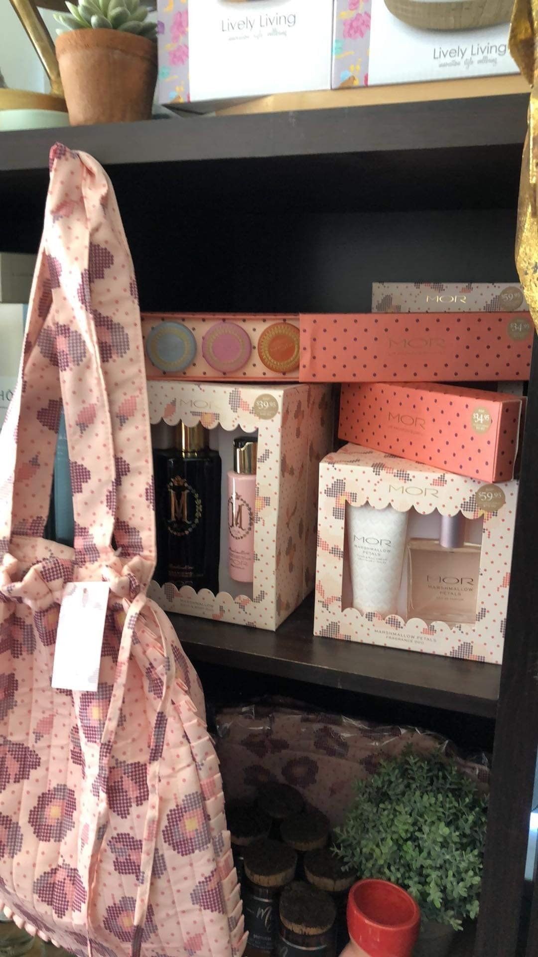 A shelf filled with boxes of perfume and a bag.