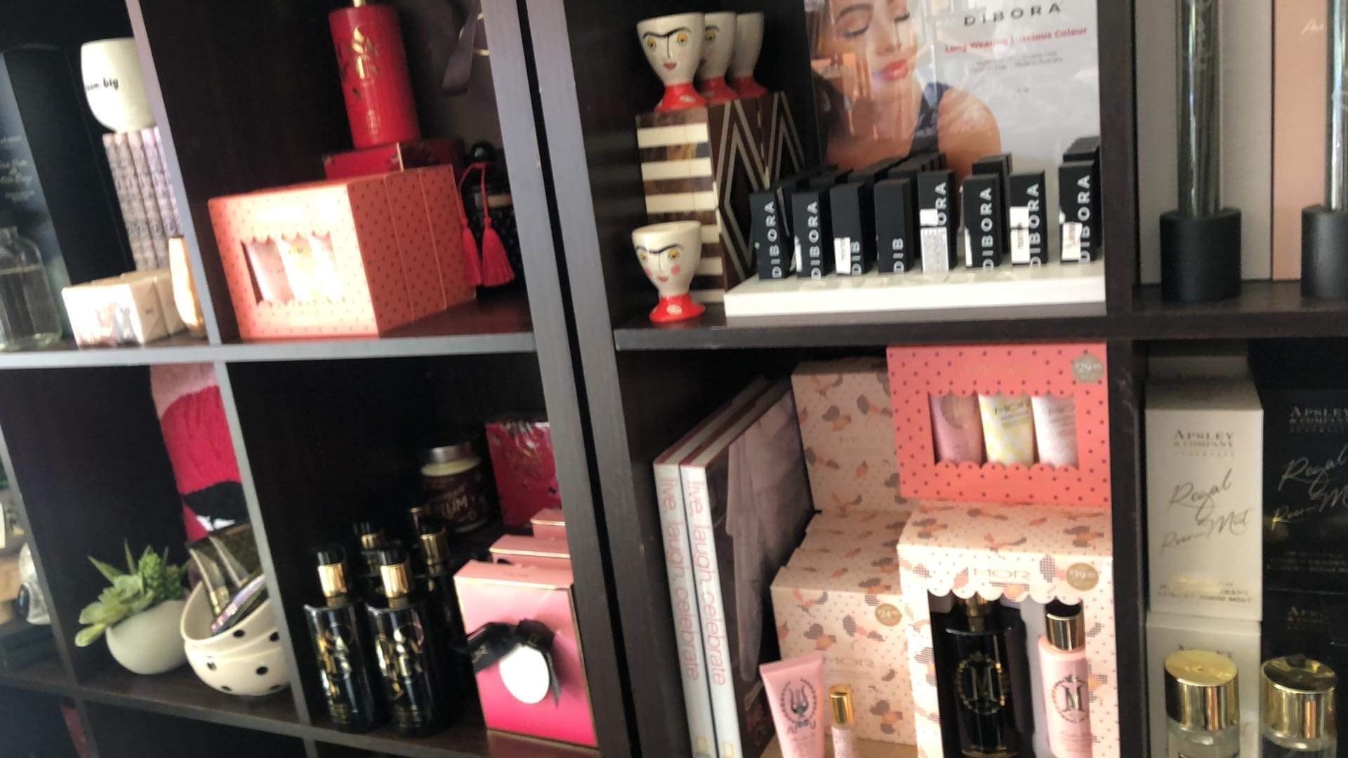 A shelf filled with a variety of items including lipsticks