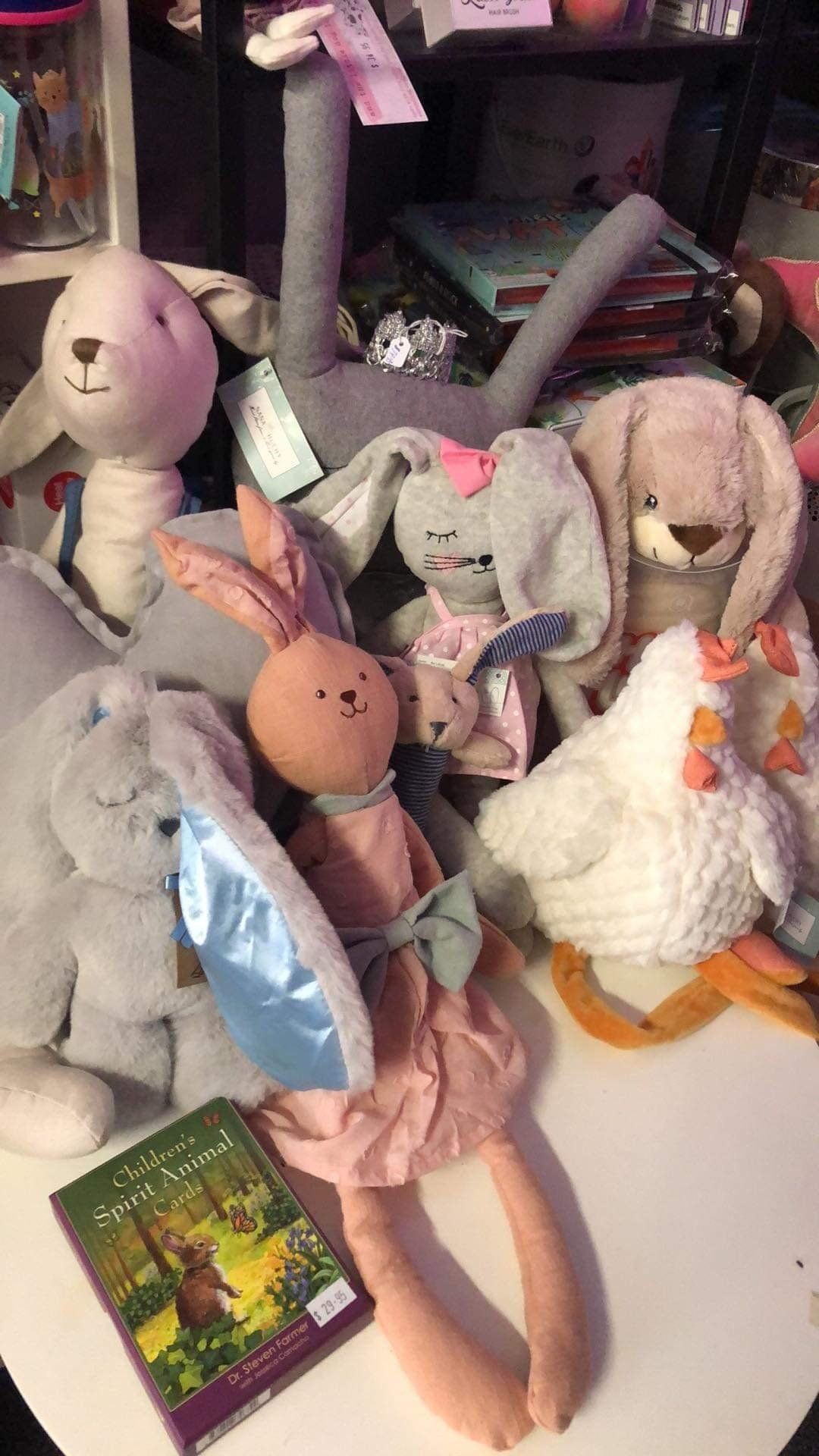 A bunch of stuffed animals are sitting on a table next to a book.
