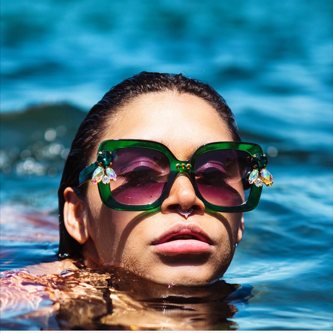Woman In Water Wearing Green Sunglasses — Homewares Store In Central Highlands,QLD