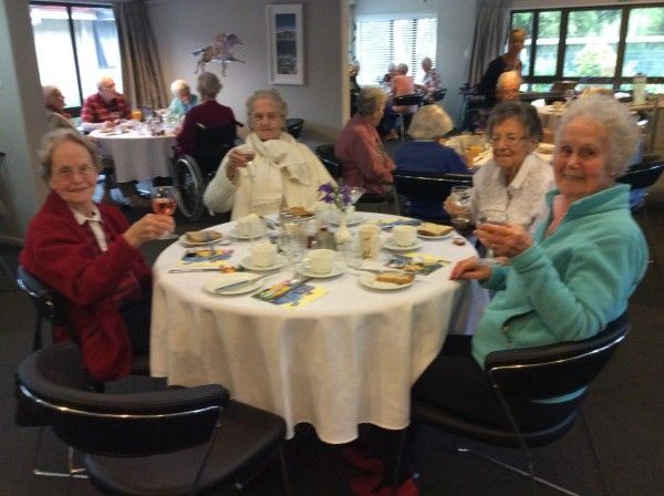 A group of people are sitting around a table drinking tea
