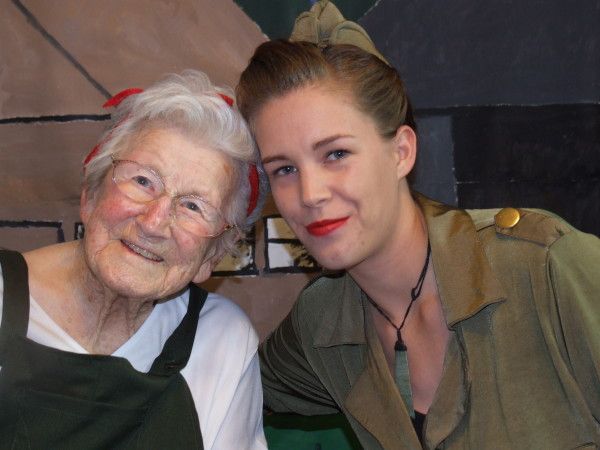 Two women posing for a picture with one wearing a military uniform