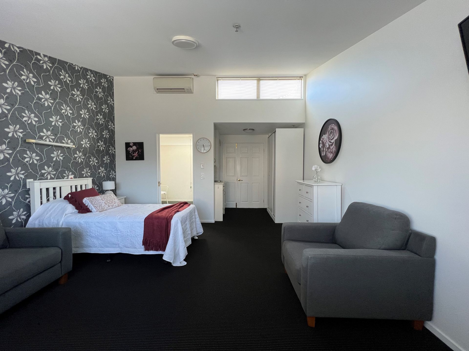 A bedroom with a large bed and two chairs
