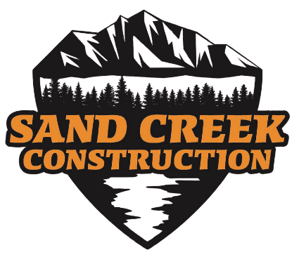 The logo for sand creek construction is a shield with mountains and trees on it.