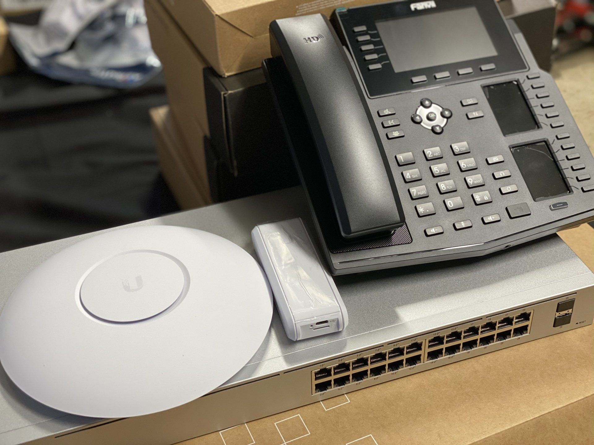 A telephone is sitting on top of a switch with wi-fi access point