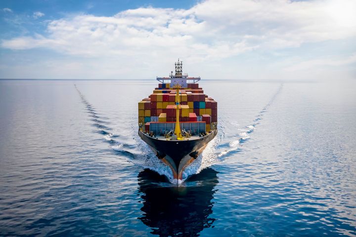 A large container ship is floating on top of a large body of water.