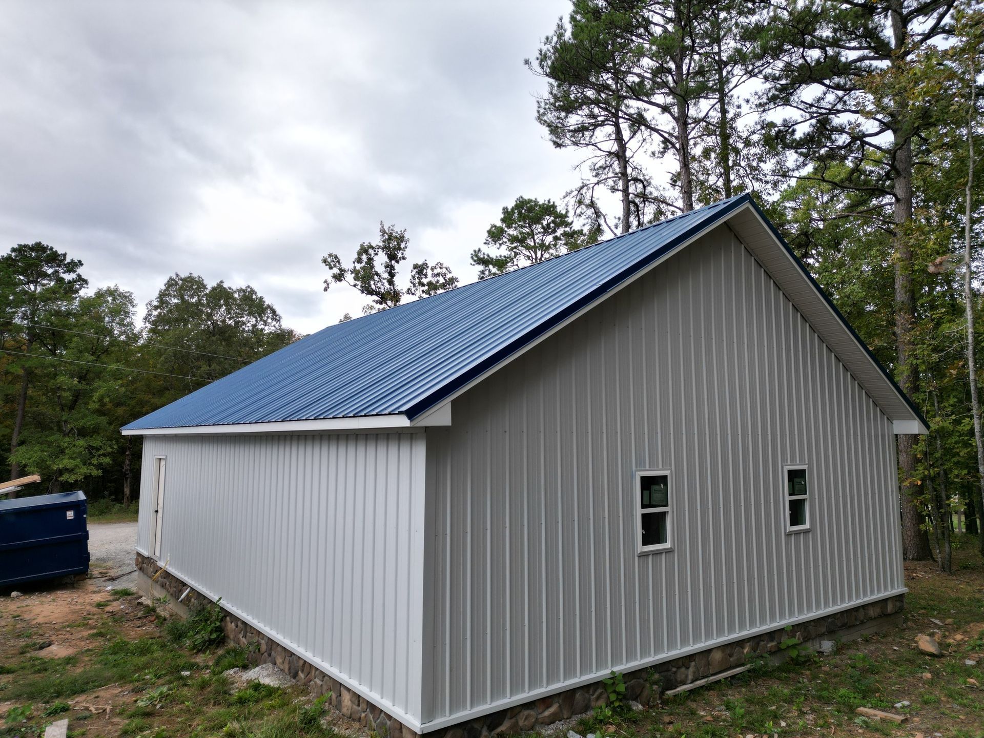 House under construction; green sheathing, porch, dormer, and dark roof.