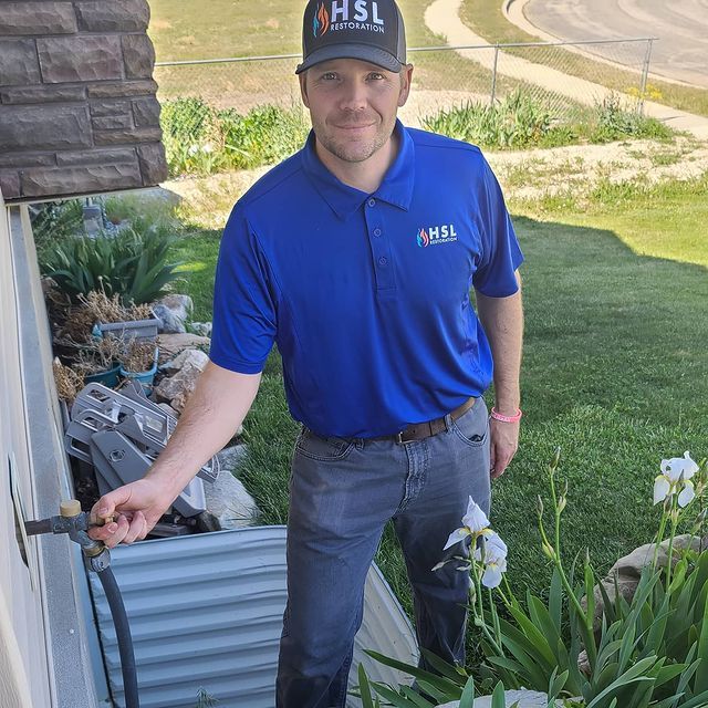 A man wearing a hsl hat and a blue shirt