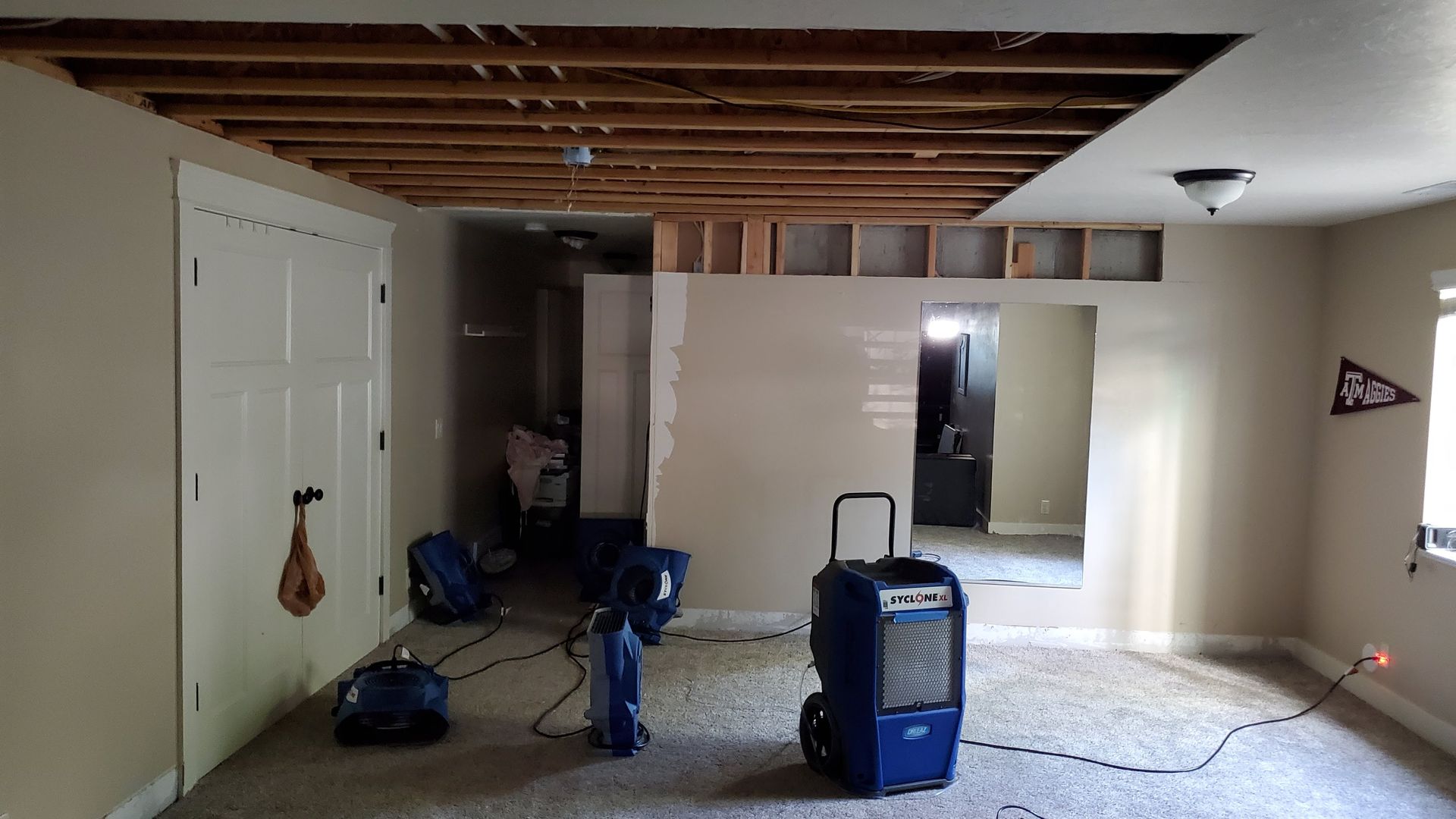 A room with a vacuum cleaner in it and a flag on the wall.