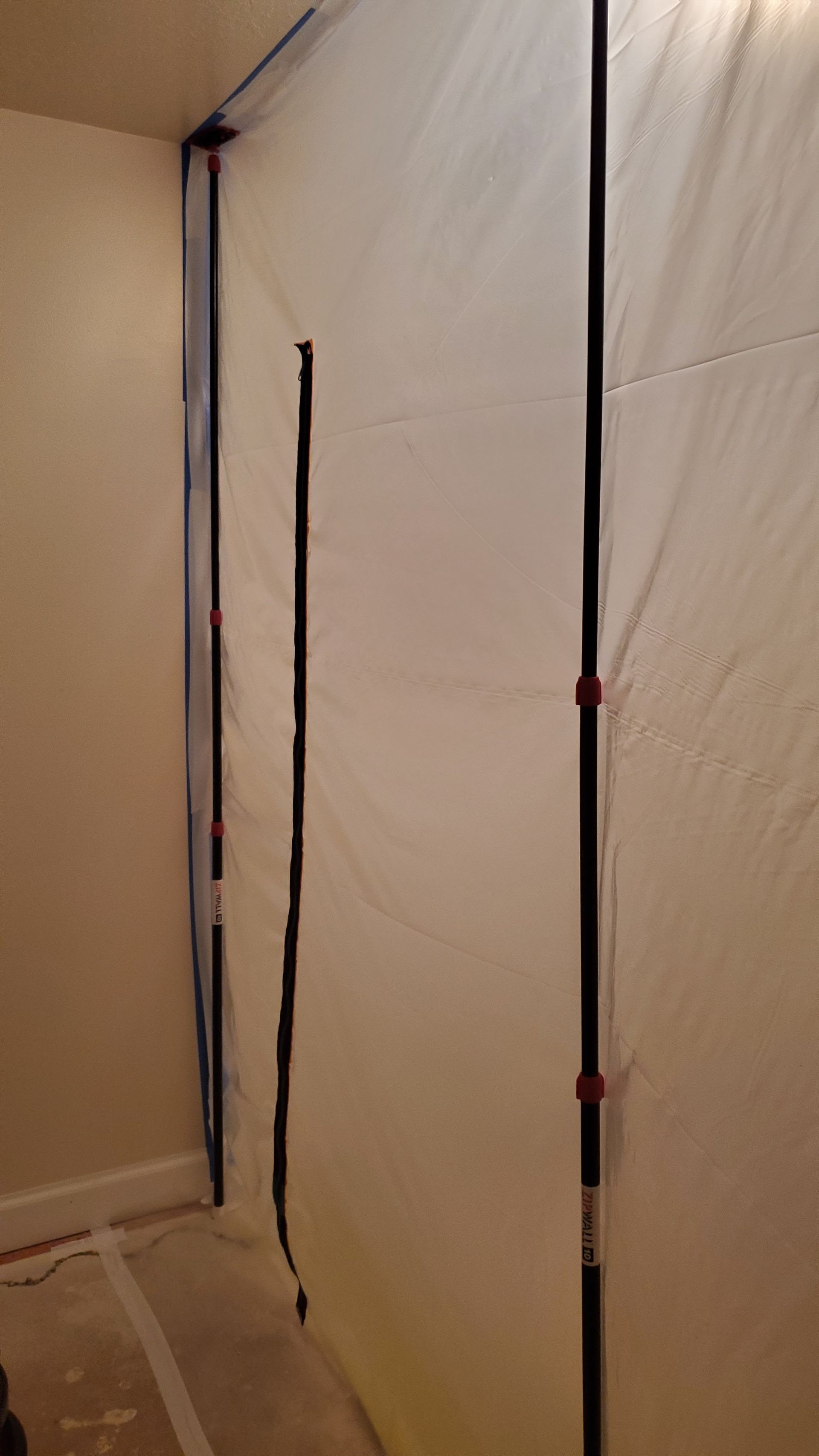 A white tarp is covering a wall in a room.