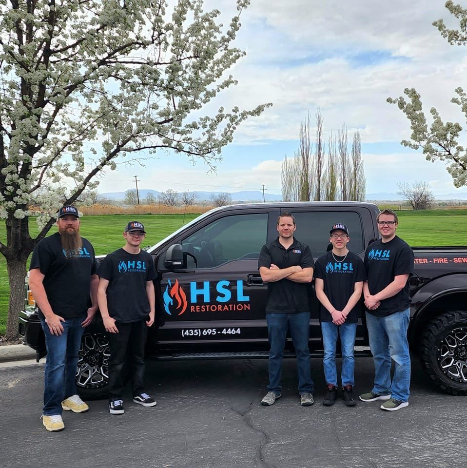 A group of men standing in front of a hsl truck