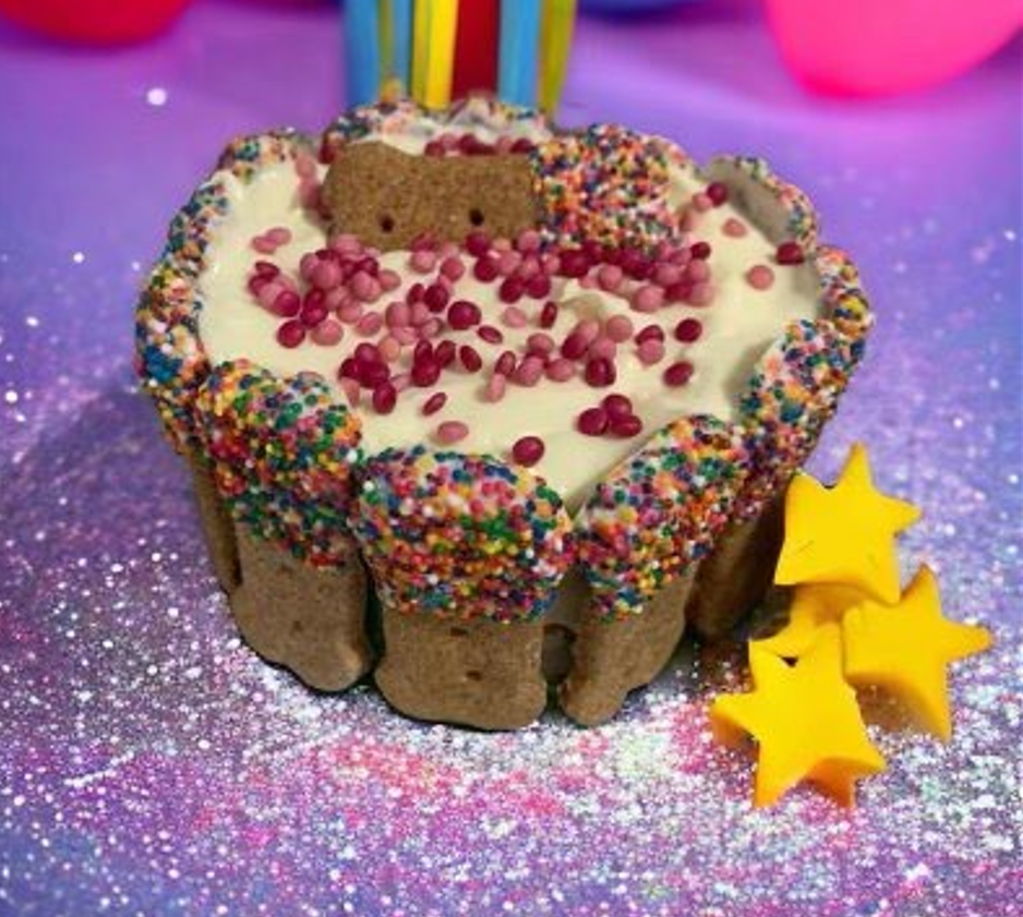 A cake with sprinkles and a cookie on top