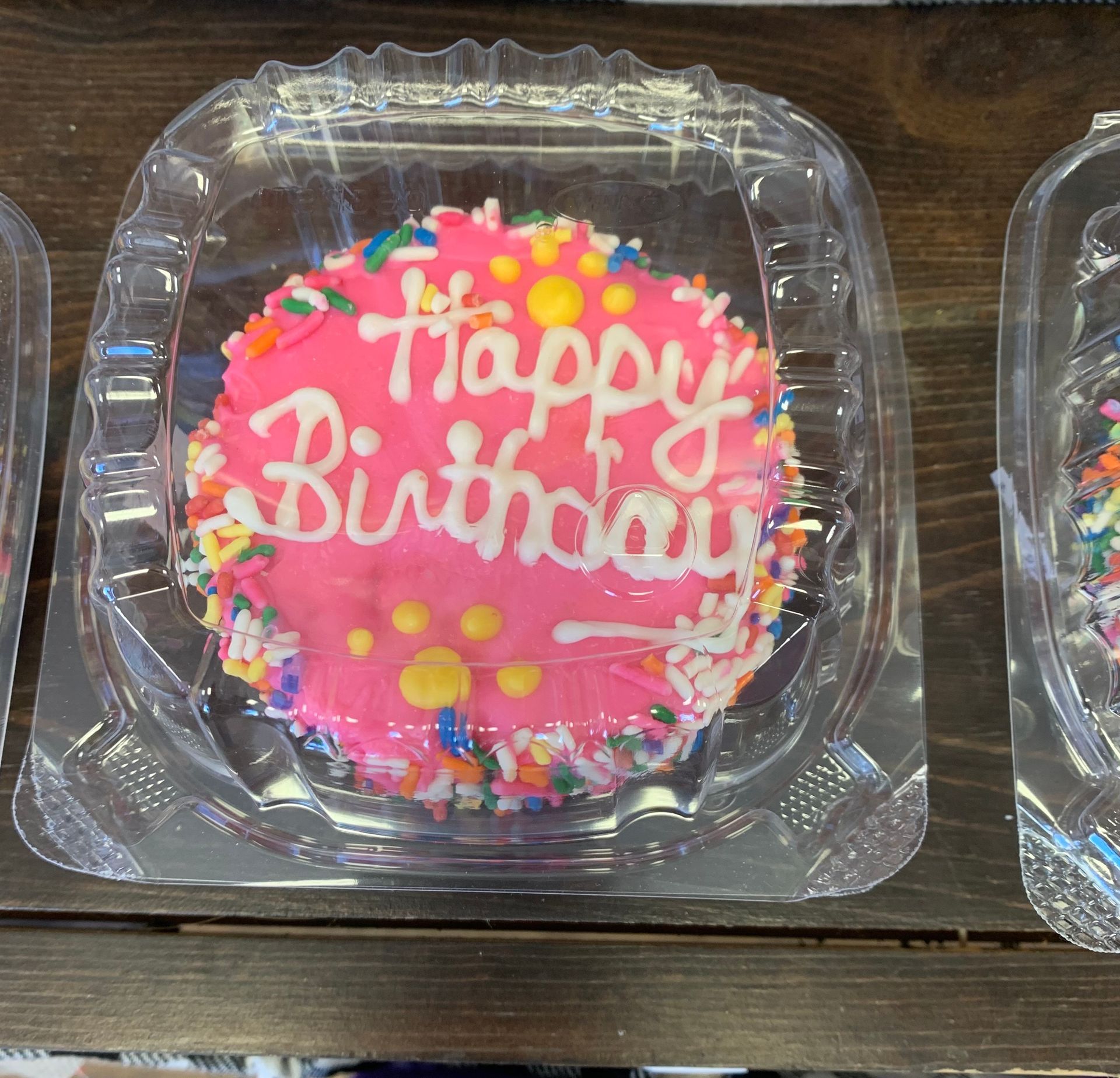 A pink cake with the words happy birthday written on it