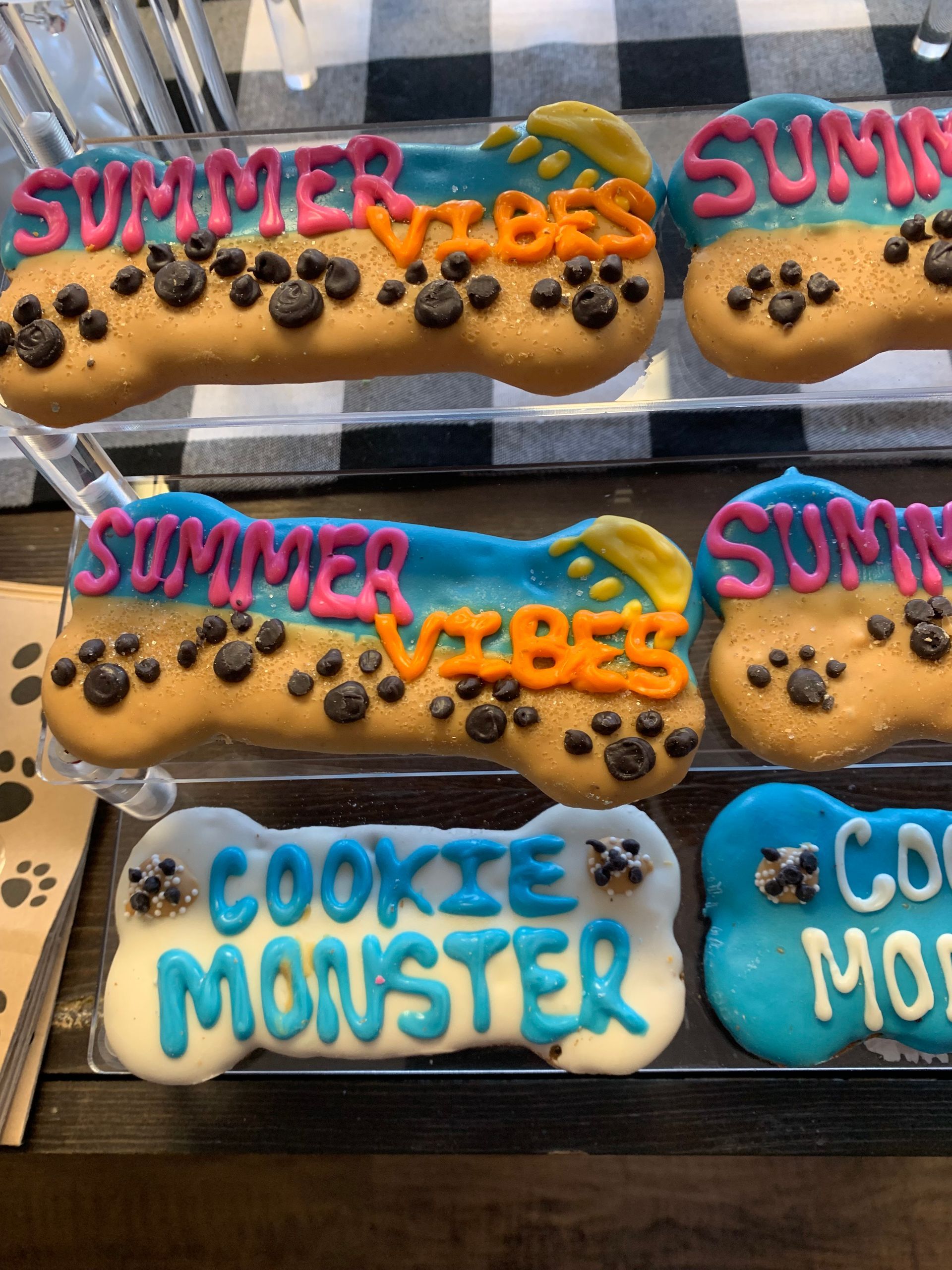 A display of dog treats that say summer vibes and cookie monster