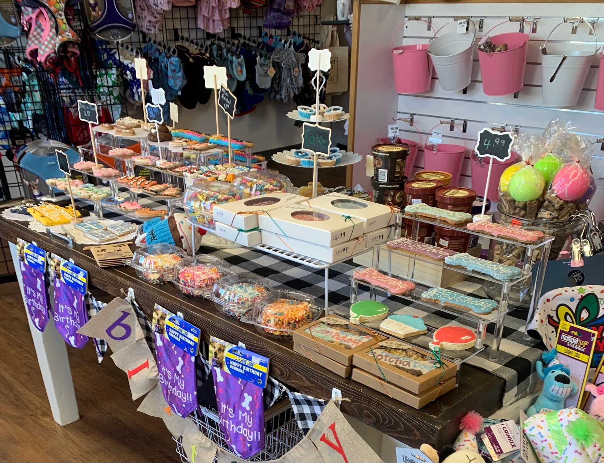 A table filled with lots of cupcakes and cookies in a store.