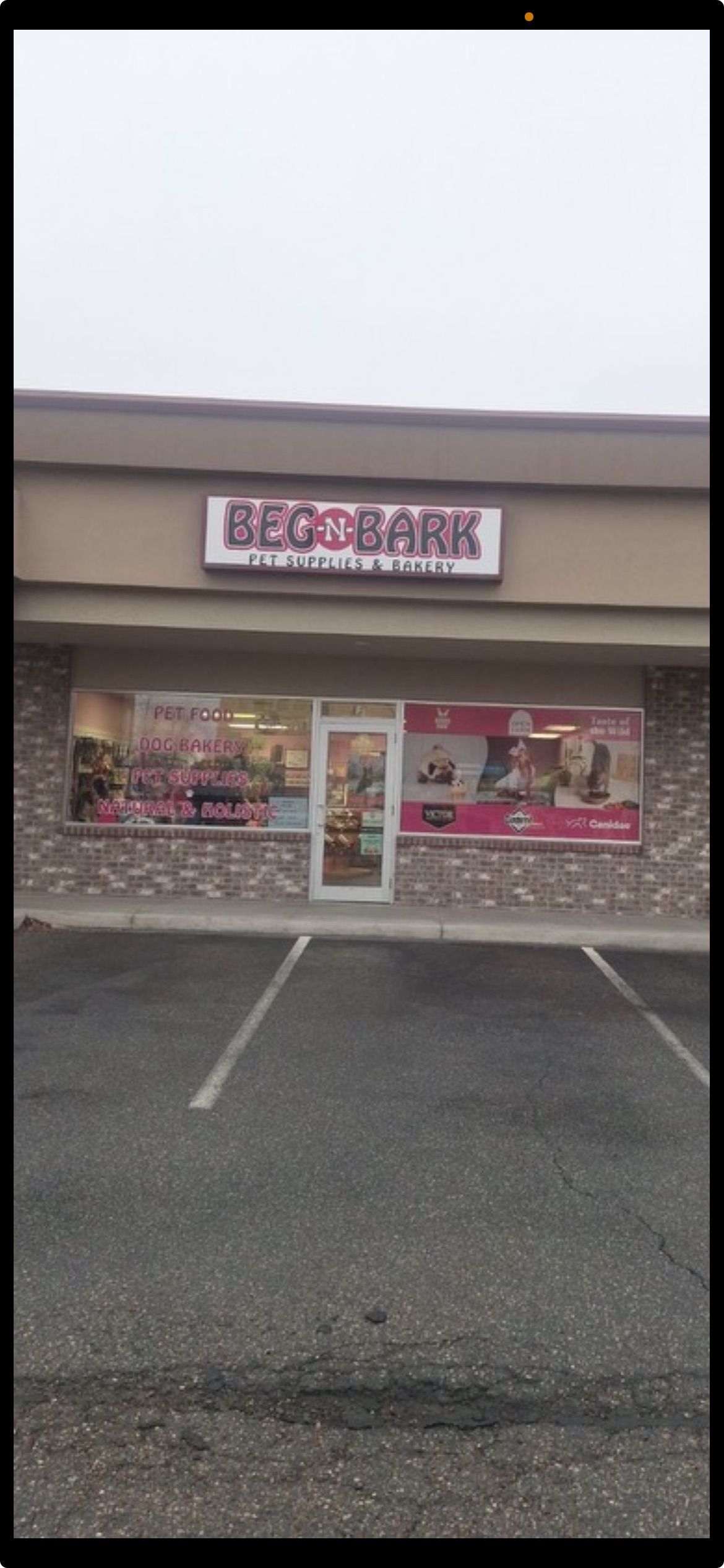 A store front with a parking lot in front of it