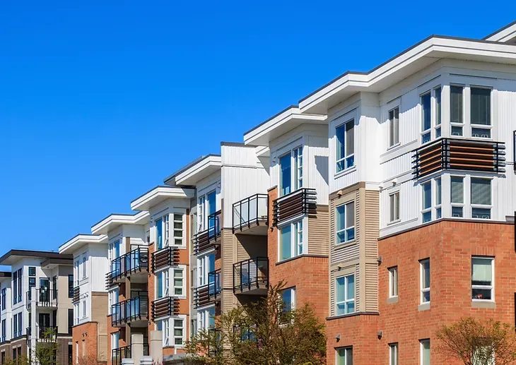 A row of apartment buildings with a blue sky in the background