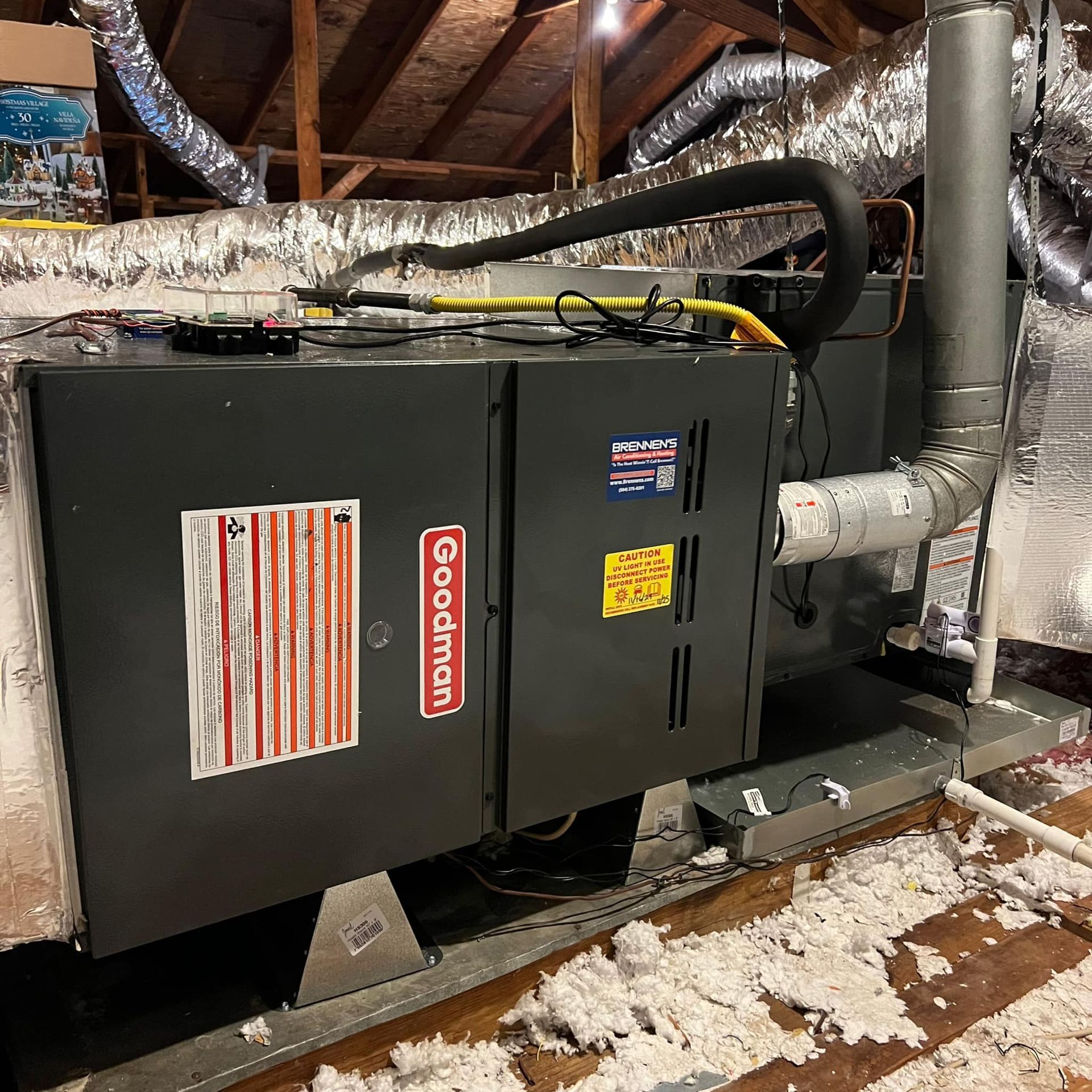 A goodman air conditioner is sitting in the attic of a house.