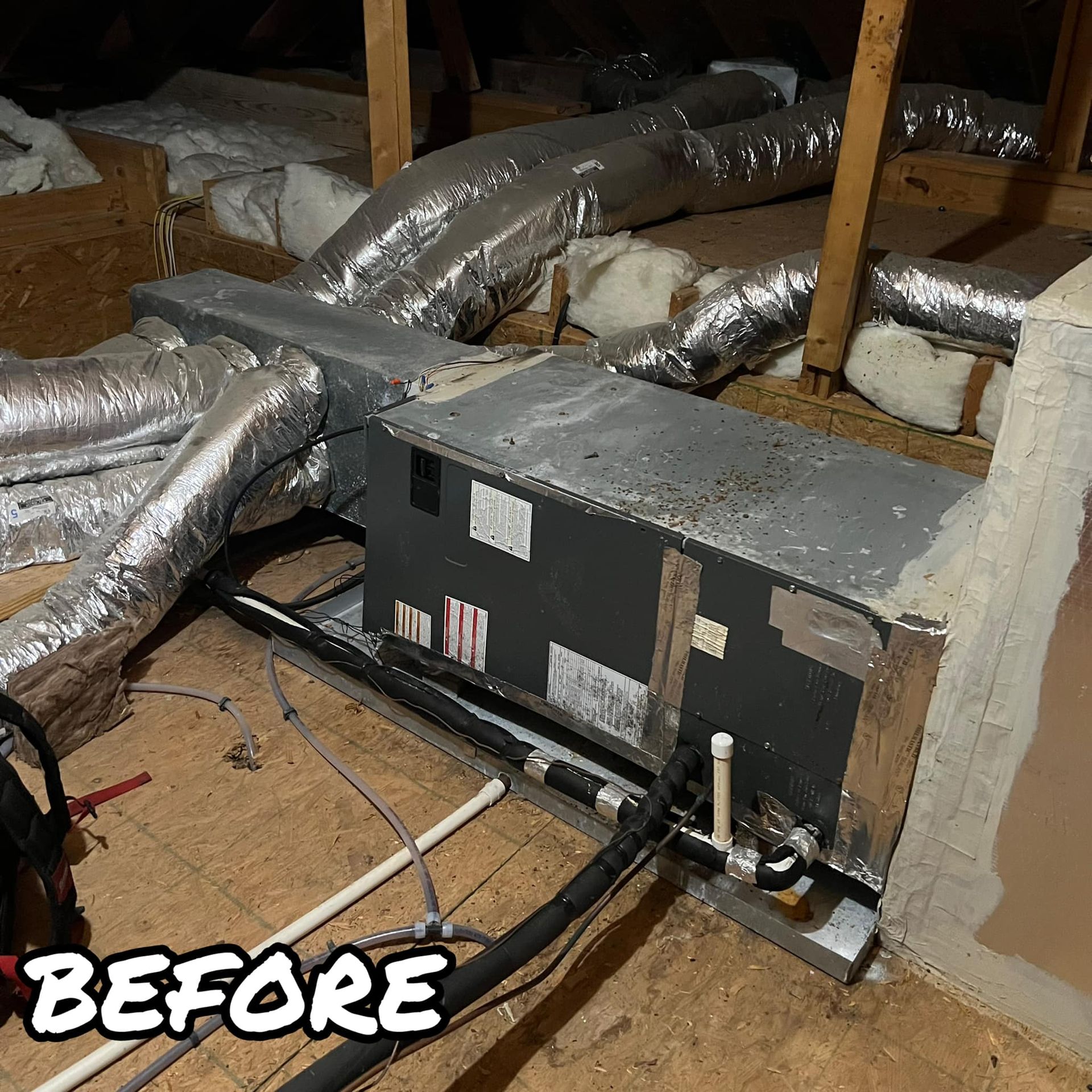 A picture of an air conditioner in an attic before being installed