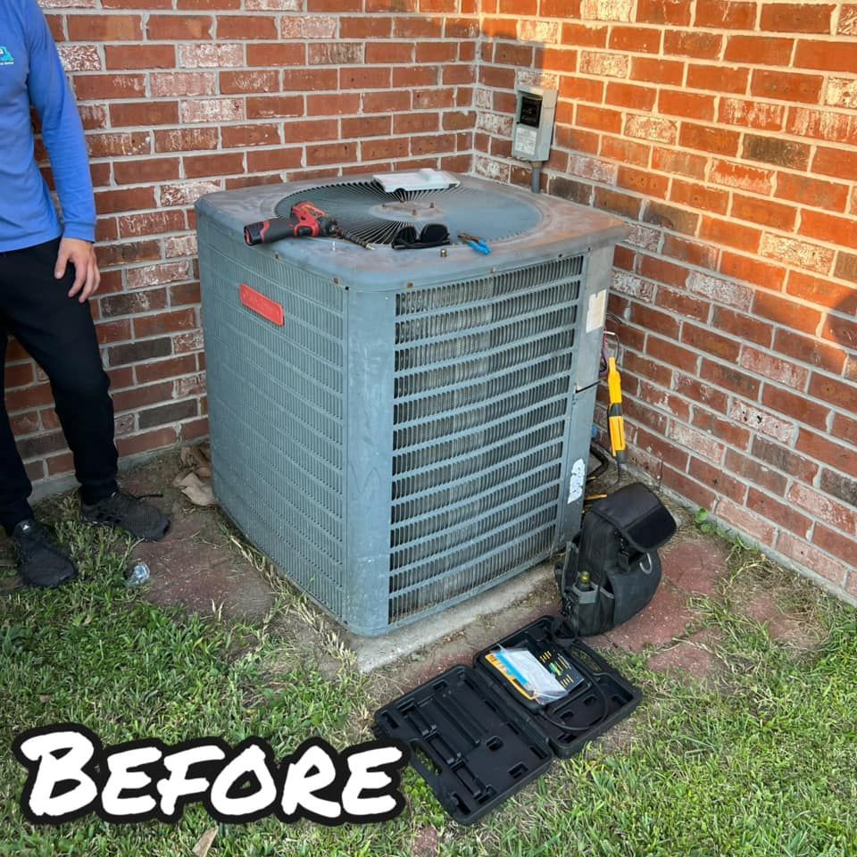 A man is standing next to an air conditioner in front of a brick wall.