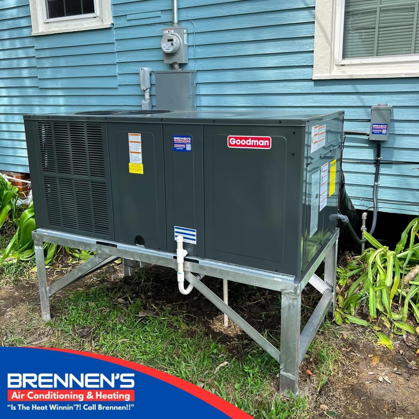 A large air conditioner is sitting on top of a metal stand in front of a blue house.